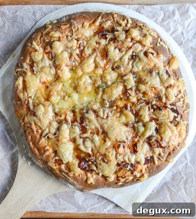 Closeup of caramelized onions and gruyere on whole wheat pizza