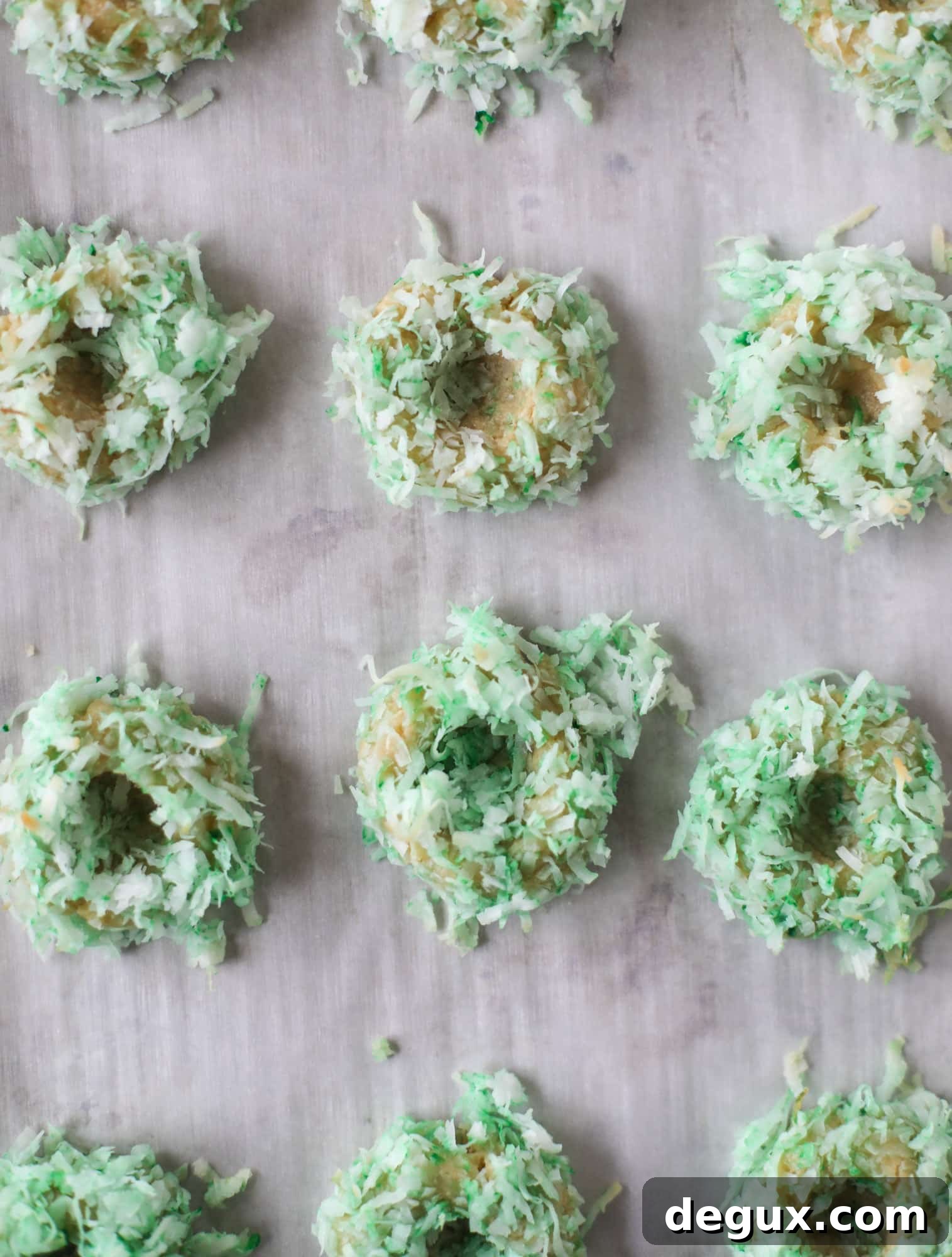 These thumbprint cookies are so perfect for the holiday season. The best butter thumbprint rolled in pink and green coconut and filled with buttercream. So festive! I personally think they look like Grinch cookies - kids love them! I howsweeteats.com #thumbprint #cookies