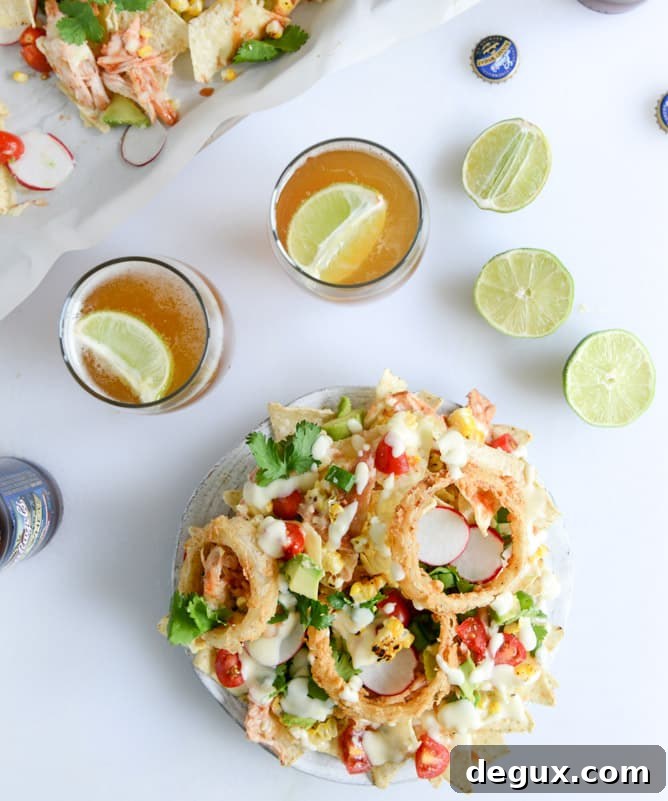summer BBQ chicken nachos with buttermilk onion rings and white cheddar queso