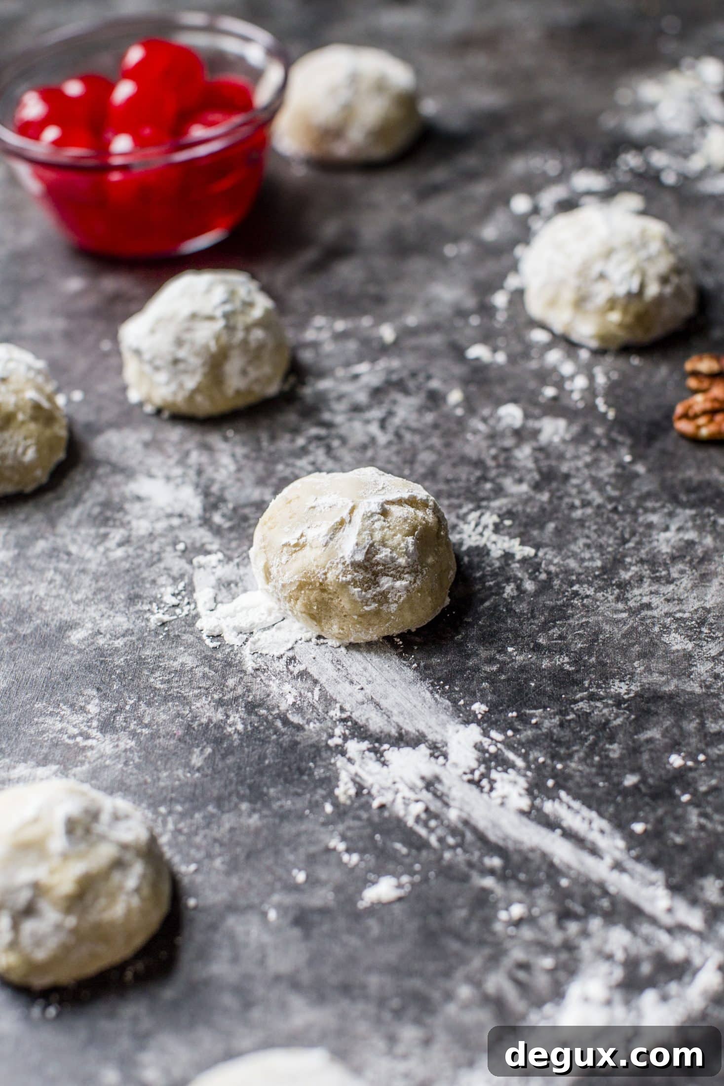 These classic butterball cookies are a favorite that my grandmother made every year at Christmas. They are a light cookie that isn't super sweet and the center is filled with either a pecan or maraschino cherry. Classic and delicious! I howsweeteats.com #butterball #cookies