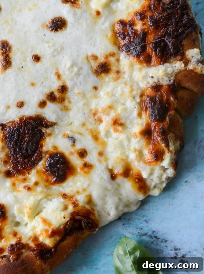 white pizza with garlic sauce and garden herbs I howsweeteats.com