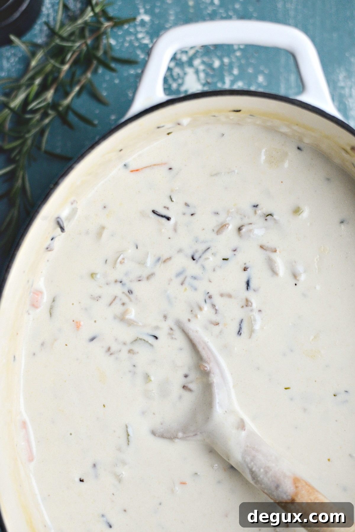 Homemade Turkey and Wild Rice Soup Recipe for Leftovers 12 creamy turkey wild rice soup in white pot with wooden spoon.