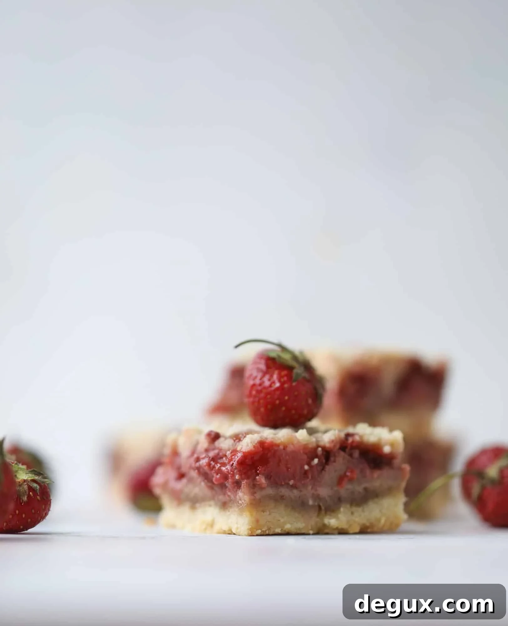 These strawberry cobbler bars are super delicious and perfect for a crowd! Made with juicy fresh strawberries, they start with a shortbread crust and end with a crumbly topping with a warm and delicious fruity filling. Huge hit! I howsweeteats.com #strawberry #cobbler #bars