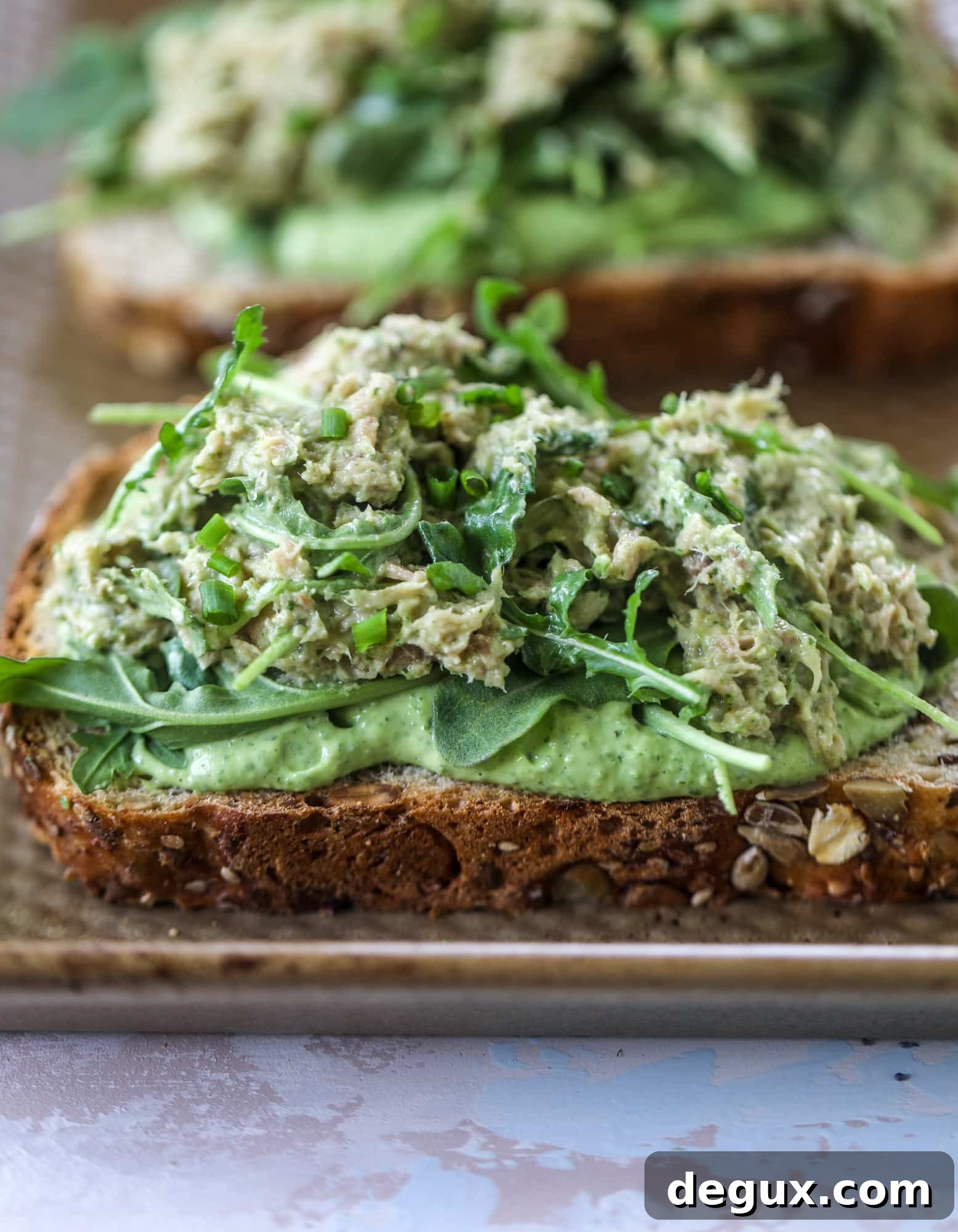These green green tuna melt tartines are a lunch dream come true! The green goddess dressing is full of avocado, greek yogurt, spinach and fresh herbs. Paired with the tuna, whole grain toast and melty cheese, it's incredibly delicious and a super easy lunch! I howsweeteats.com #green #goddess #tune #salad #melts