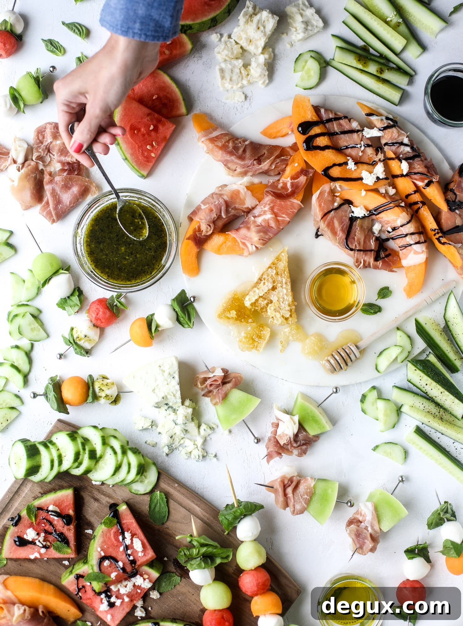 Create a melon summer snacking board with watermelon, cantaloupe, cucumber and honeydew. Drizzled with balsalmic, pesto, fresh herbs and paired with prosciutto and marinated mozzarella. I howsweeteats.com #melon #summer #snack #cheese #board #watermelon