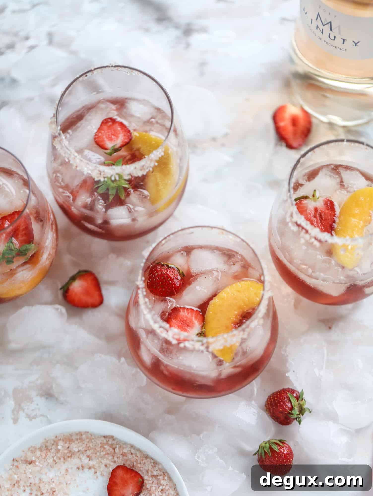 Tequila rosé spritz cocktail: muddled strawberries and honey, a shot of tequila, finished with rosé wine.