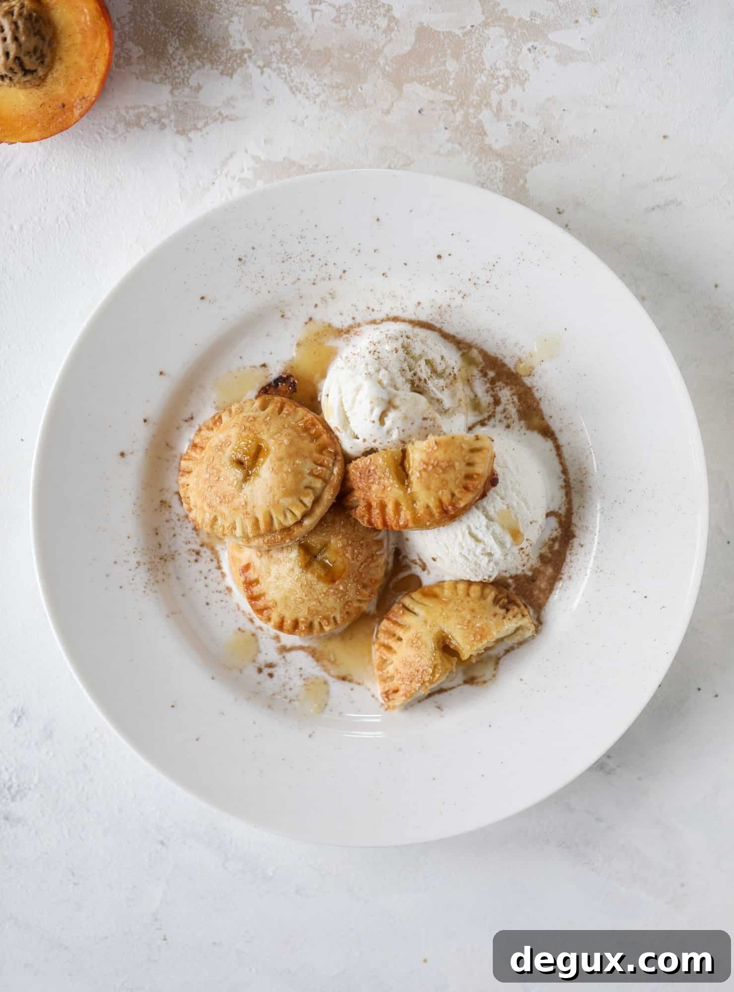 These little peach hand pies are super easy to make and oh-so delicious for summer! A warm and syrupy homemade peach filling made with brown sugar and bourbon, stuck inside a flakey all-butter crust and sprinkled with coarse sugar. SO GOOD. I howsweeteats.com #peach #hand #pies #mini #dessert #summer