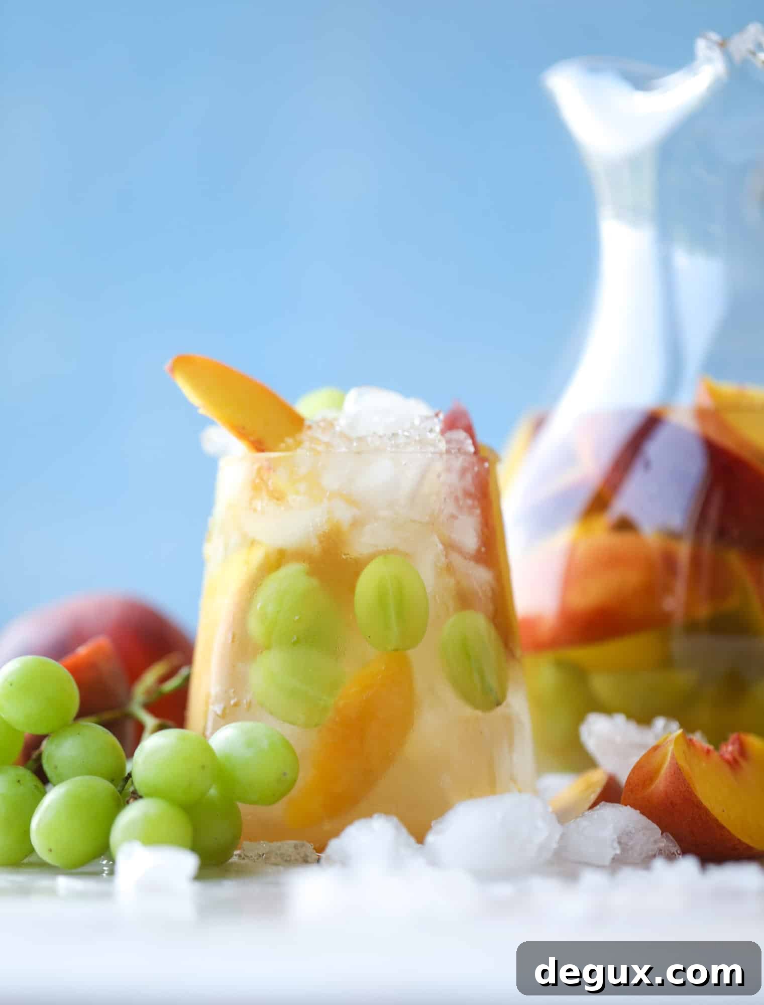 Pinot grigio sangria with peach nectar, fresh and frozen peach slices, brandy and bubbles. Frozen green grapes keep it cold without diluting the drink.