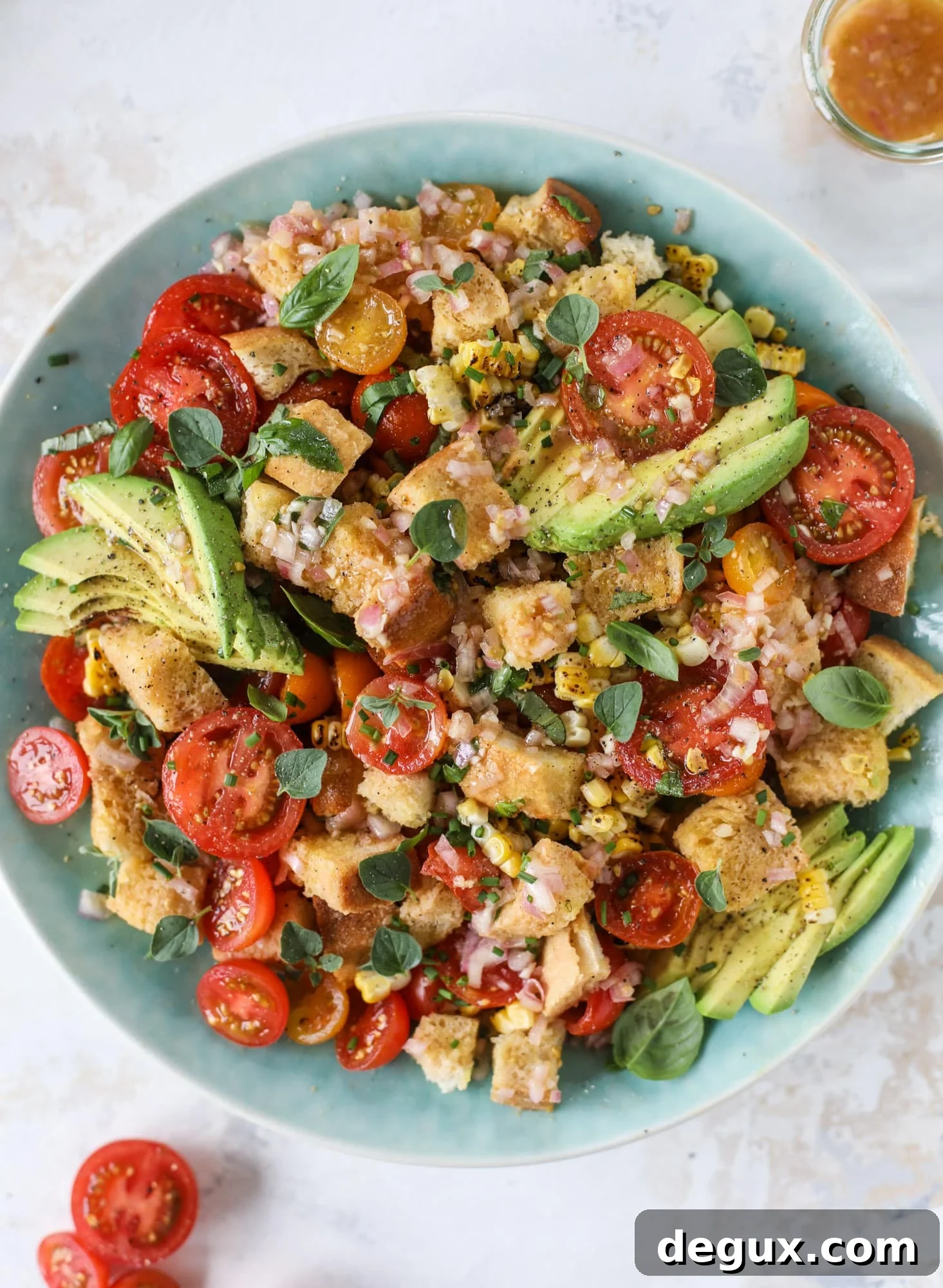 This is the perfect tomato panzanella salad! It's full of juicy, bursting, sweet tomatoes, toasted sourdough bread cubes, fresh herbs, grilled corn, sliced avocado and an incredible homemade dressing that blankets everything in deliciousness.