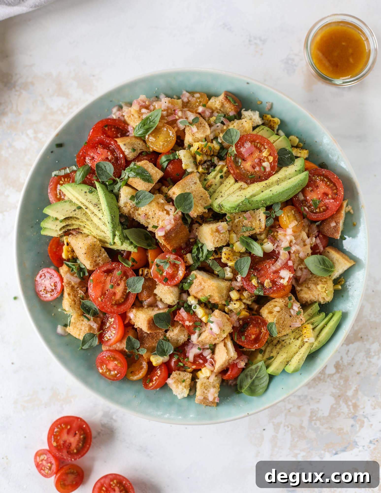 This is the perfect tomato panzanella salad! It's full of juicy, bursting, sweet tomatoes, toasted sourdough bread cubes, fresh herbs, grilled corn, sliced avocado and an incredible homemade dressing that blankets everything in deliciousness.