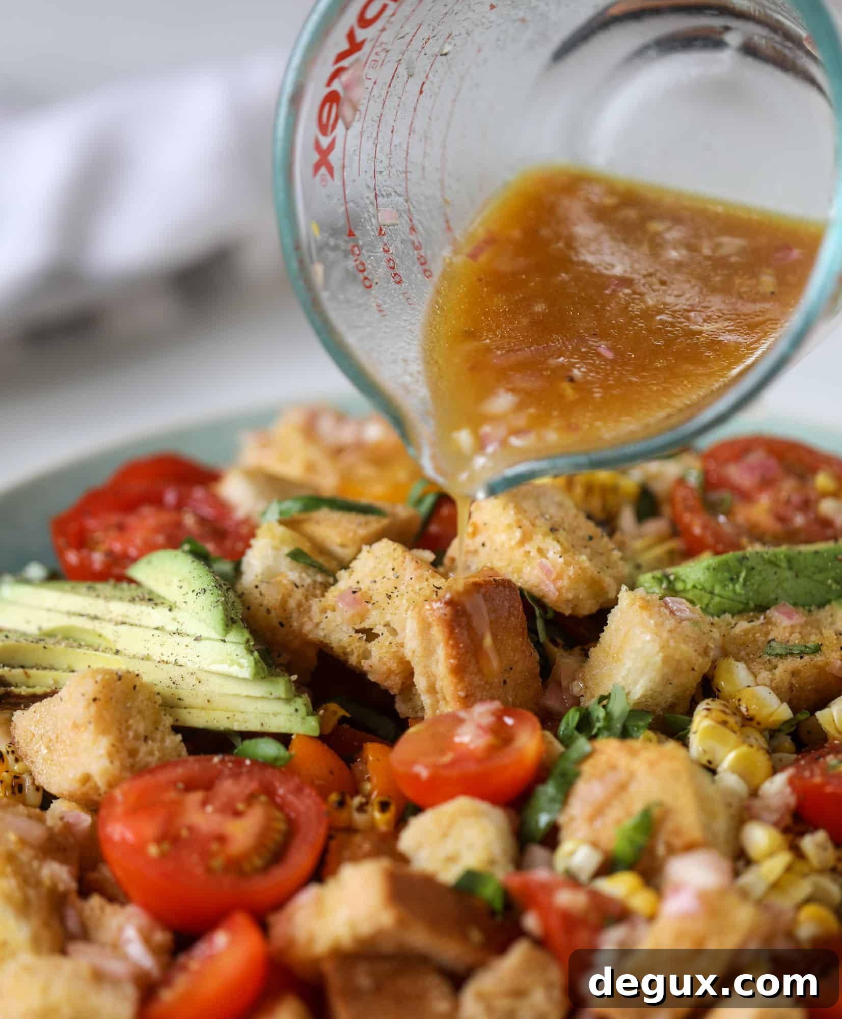 This is the perfect tomato panzanella salad! It's full of juicy, bursting, sweet tomatoes, toasted sourdough bread cubes, fresh herbs, grilled corn, sliced avocado and an incredible homemade dressing that blankets everything in deliciousness.