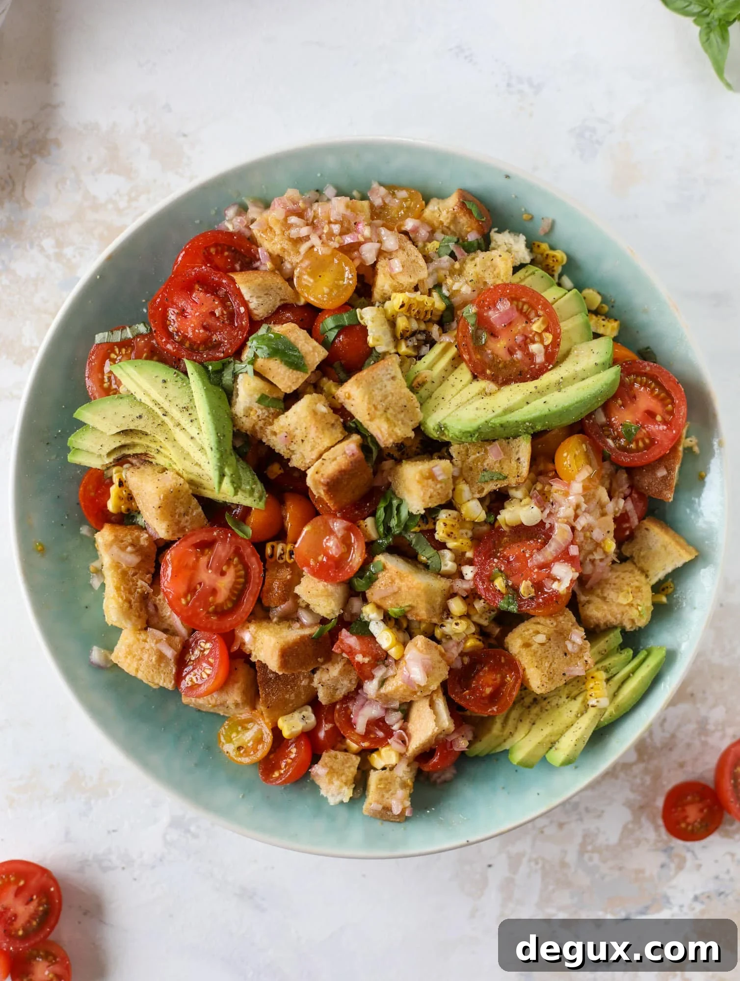 This is the perfect tomato panzanella salad! It's full of juicy, bursting, sweet tomatoes, toasted sourdough bread cubes, fresh herbs, grilled corn, sliced avocado and an incredible homemade dressing that blankets everything in deliciousness.