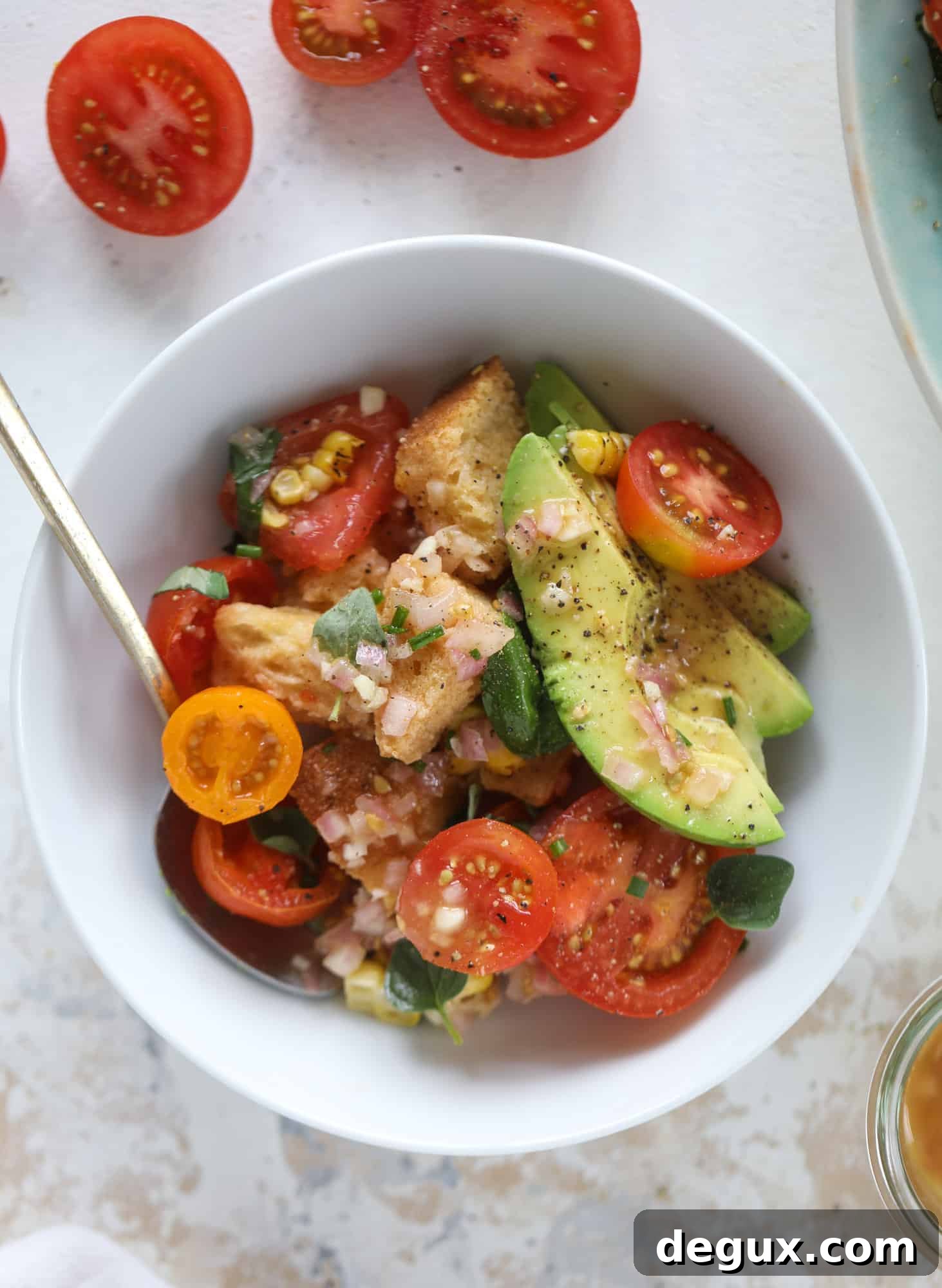 This is the perfect tomato panzanella salad! It's full of juicy, bursting, sweet tomatoes, toasted sourdough bread cubes, fresh herbs, grilled corn, sliced avocado and an incredible homemade dressing that blankets everything in deliciousness.