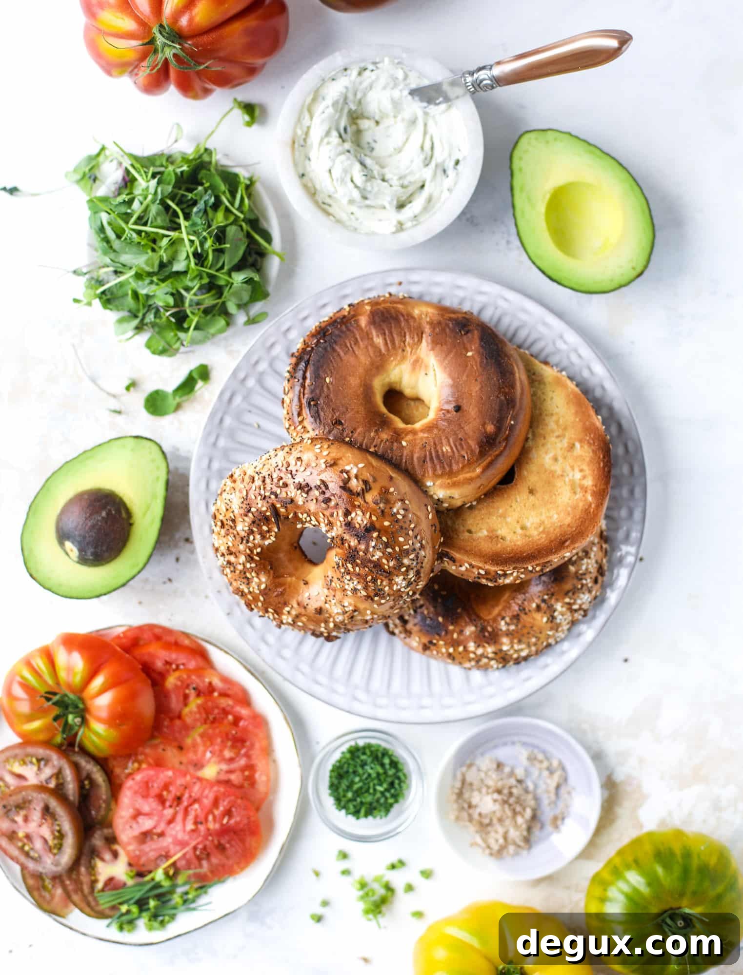 These avocado tomato sandwiches are the perfect lunch! Complete with veggie cream cheese, smoked sea salt, fresh chives and microgreens, the sliced avocado and heirloom tomatoes are sandwiched on an everything bagel for a flavor explosion. I howsweeteats.com #avocado #tomato #sandwich #healthy #lunch
