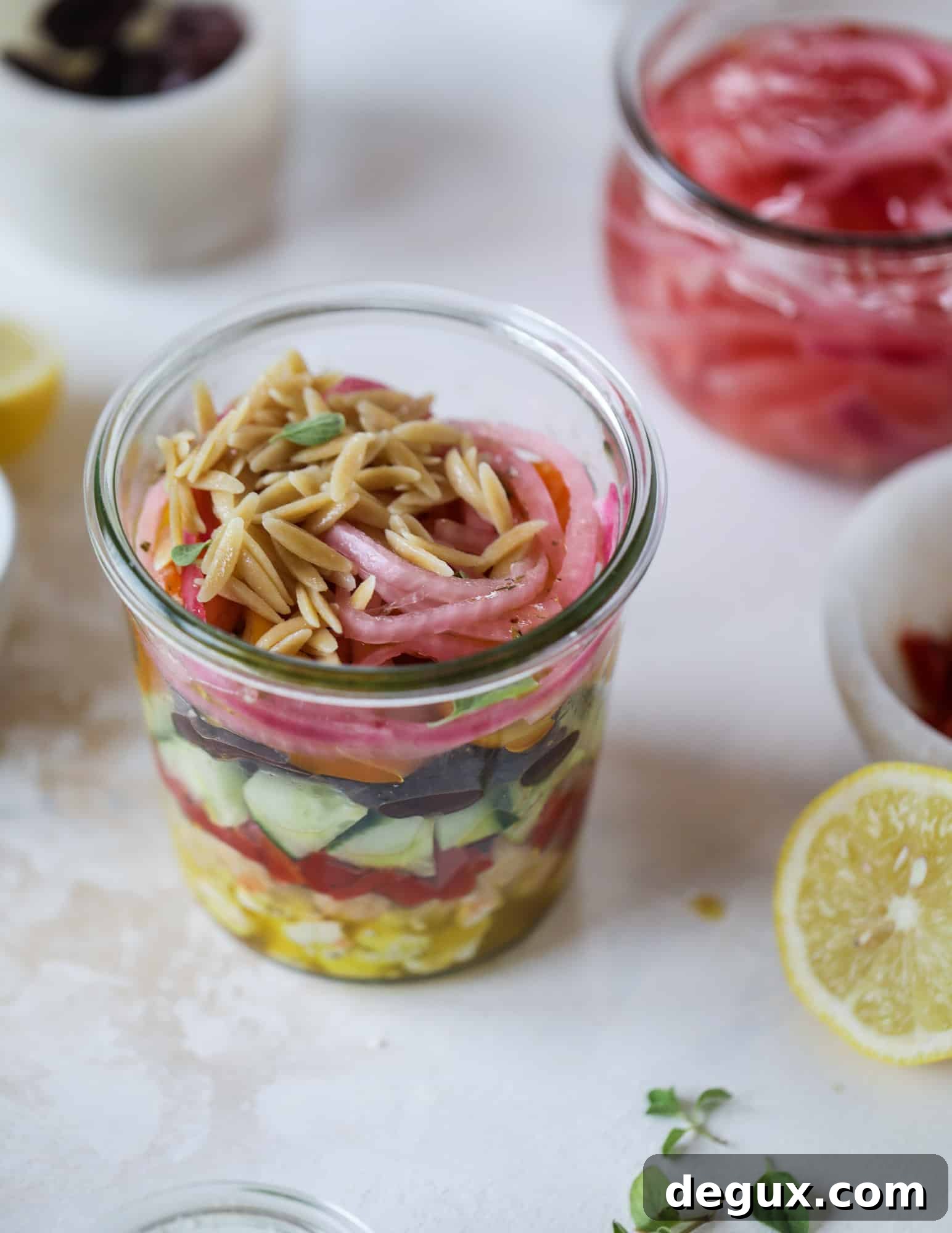 This incredible greek orzo salad in a jar is to die for! The recipe is so easy and flavorful, super satisfying and perfect for meal prep. This salad in a jar is a delicious lunch idea for the weekdays and keeps you feeling full and happy! I howsweeteats.com #salad #jar #greek #orzo #recipes #healthy #lunch #mealprep