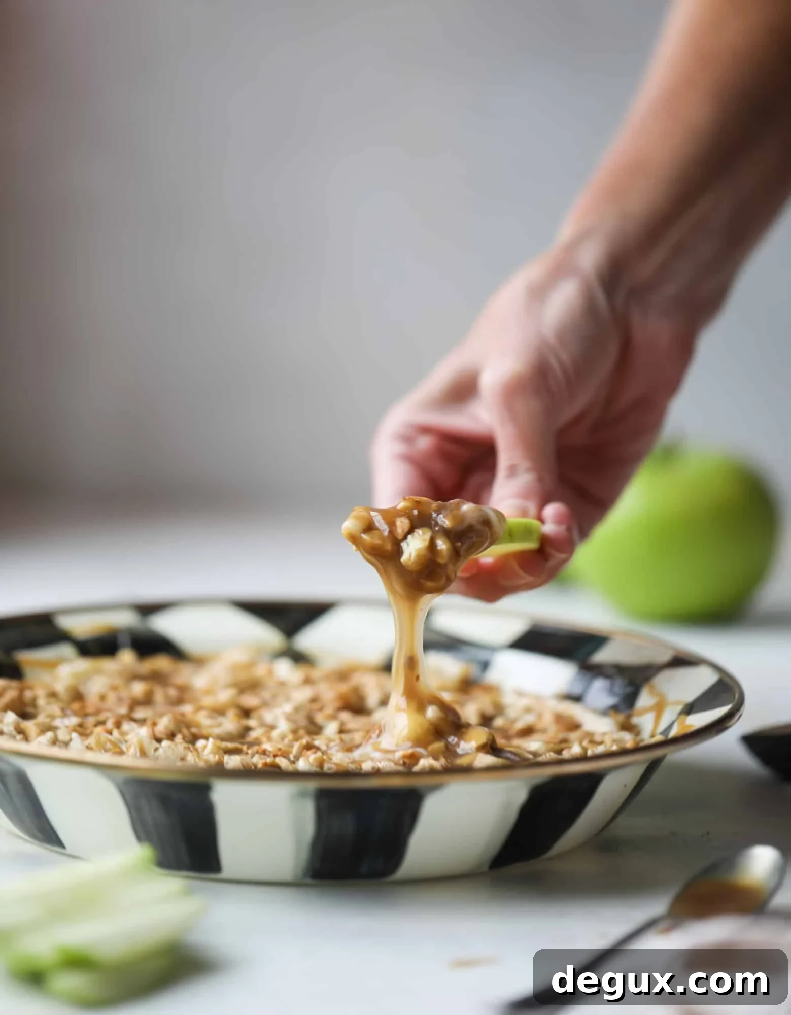 This caramel apple dip is my take on the old-school cream cheese based dip that is super delicious! Here, we have a mascarpone base with a bourbon caramel sauce, topped with roasted chopped cashews. Just add apples! I howsweeteats.com #caramel #apple #dip #appetizer #snack