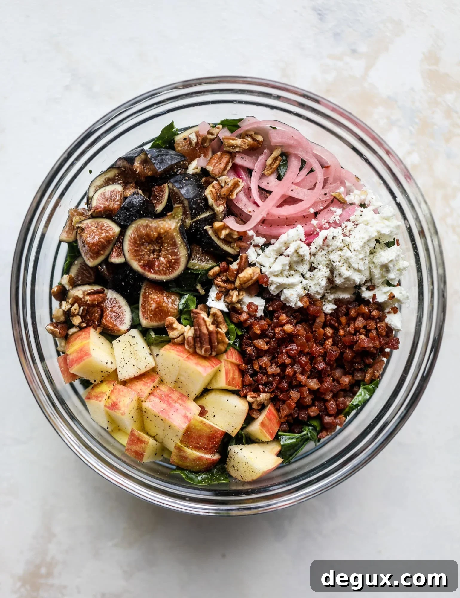 This fall kale salad is perfect for the season and full of so much delicious flavor! Shredded kale, honeycrisp apple, fresh figs, pancetta, pickled onions, pecans and goat cheese come together with a maple cider vinaigrette for salad heaven. I howsweeteats.com #fall #kale #salad #apples #figs #pecans