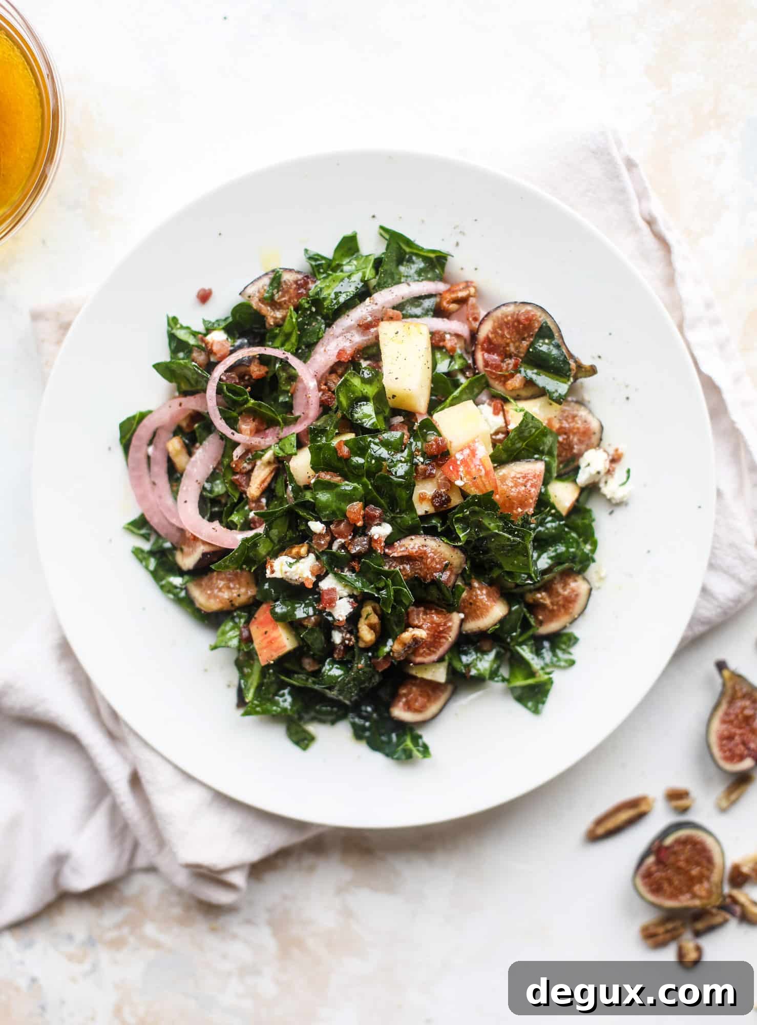 This fall kale salad is perfect for the season and full of so much delicious flavor! Shredded kale, honeycrisp apple, fresh figs, pancetta, pickled onions, pecans and goat cheese come together with a maple cider vinaigrette for salad heaven. I howsweeteats.com #fall #kale #salad #apples #figs #pecans