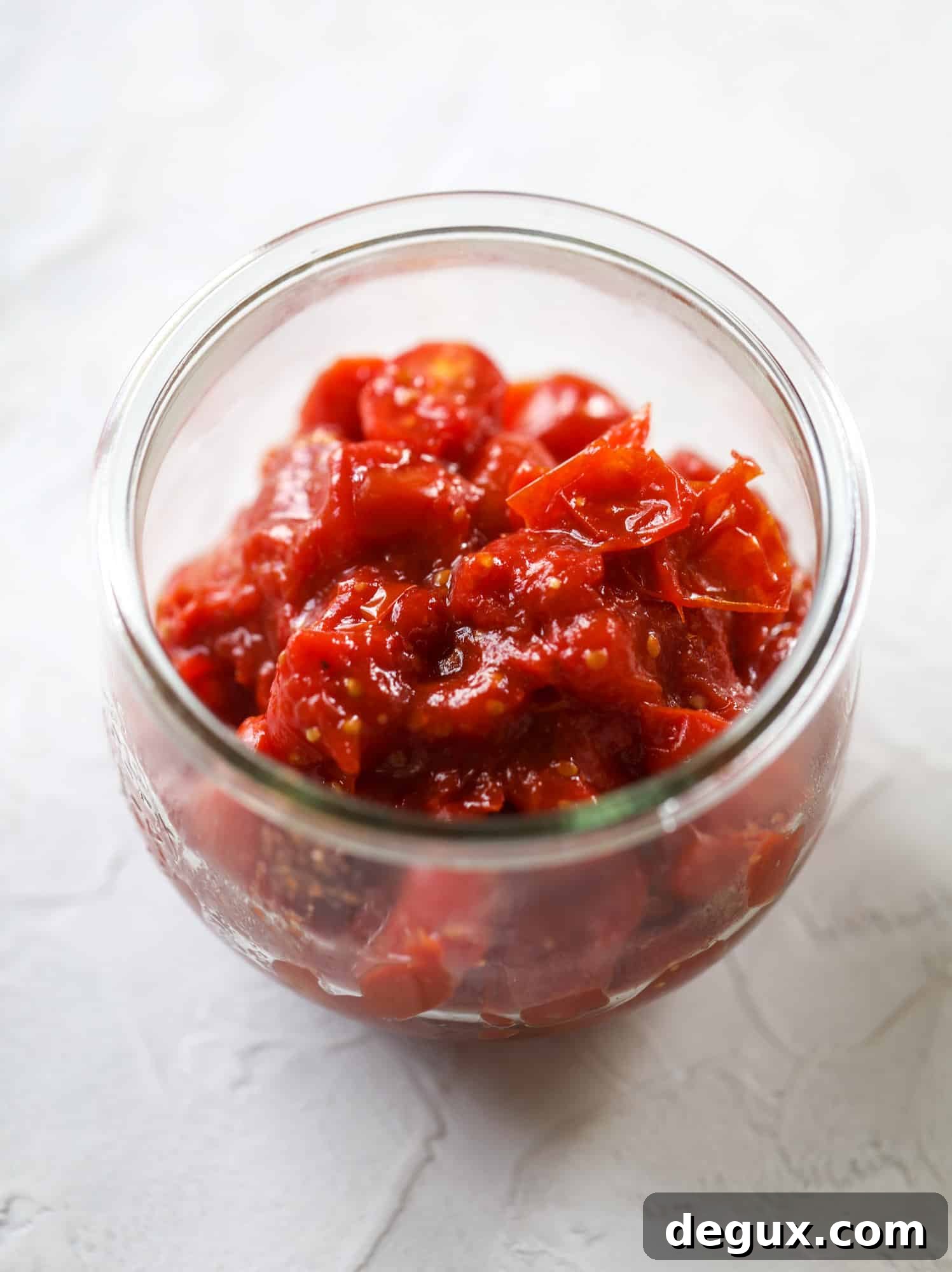 Layered ricotta, pesto, and tomato jam in a jar