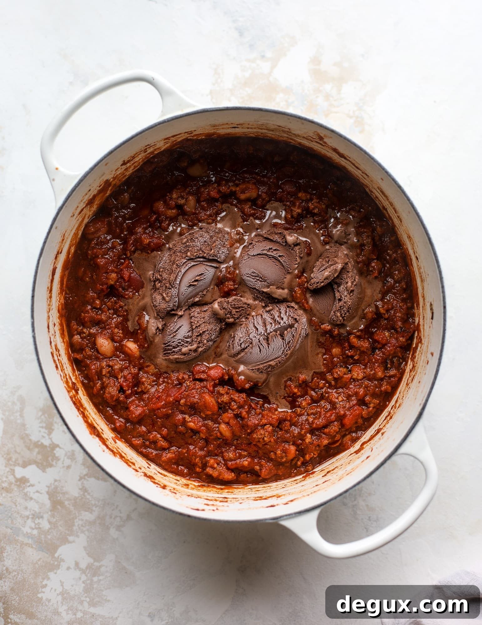 Fire and Ice Chili Recipe: Spicy-Sweet Chili with Cooling Yogurt 3 This fire and ice chili has a secret ingredient that makes it rich, velvety and insanely delicious. Dark chocolate ice cream is stirred in before serving and adds a crazy depth of flavor while bringing so much richness to your favorite bowl. You have to try it! I howsweeteats.com #chili #recipe #ice #cream #chili #bar