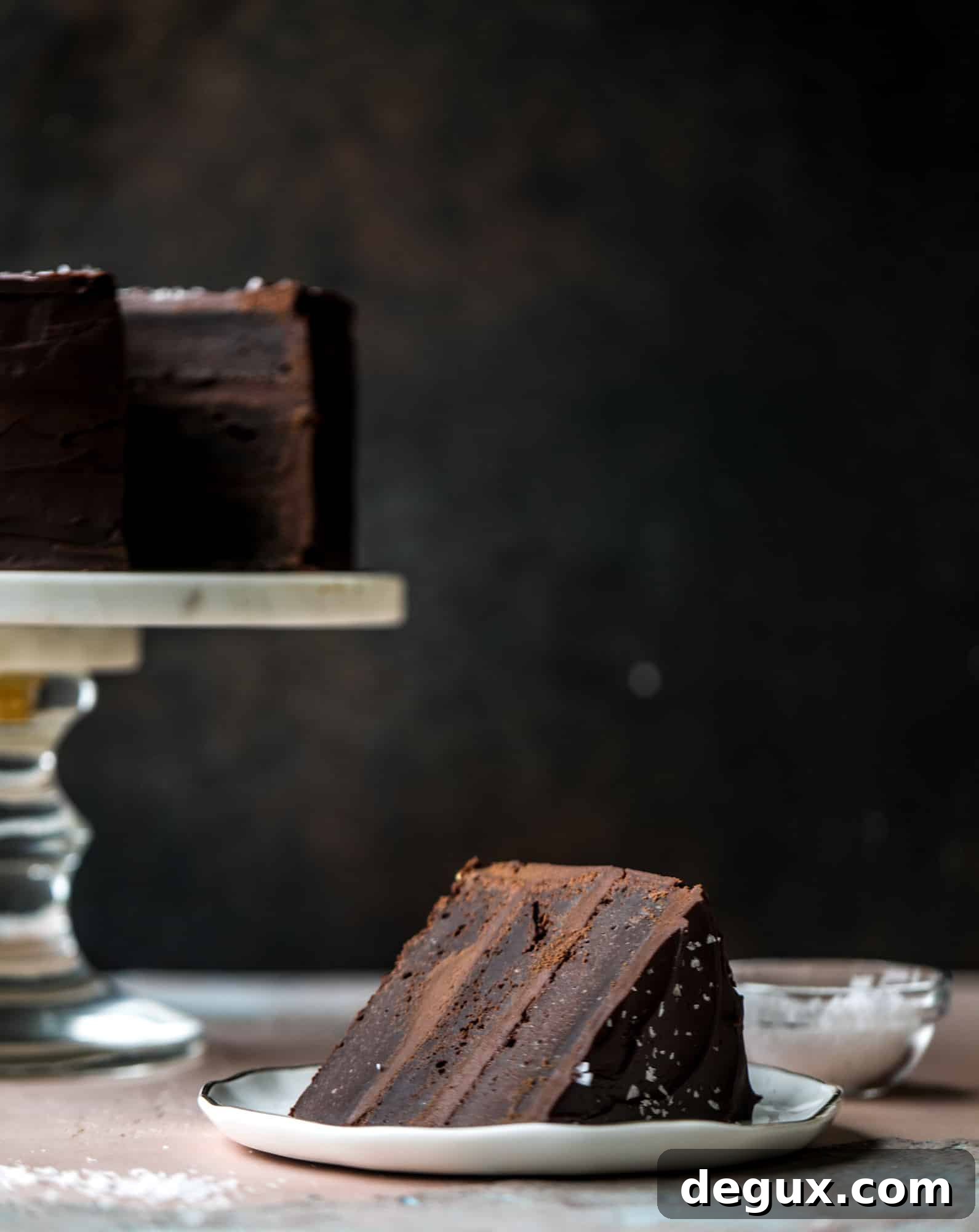 This salted dark chocolate stout cake is absolutely divine! It's ridiculously rich and perfect for a crowd or a party. Pumpkin stout batter is baked into fluffy laters and covered in a super fudgy chocolate ganache. Perfect for chocolate lovers! I howsweeteats.com #dark #chocolate #stout #cake #salted