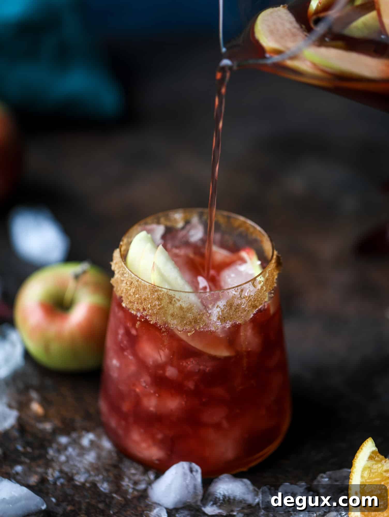 Glasses of red apple cider sangria with cinnamon sugar rims.