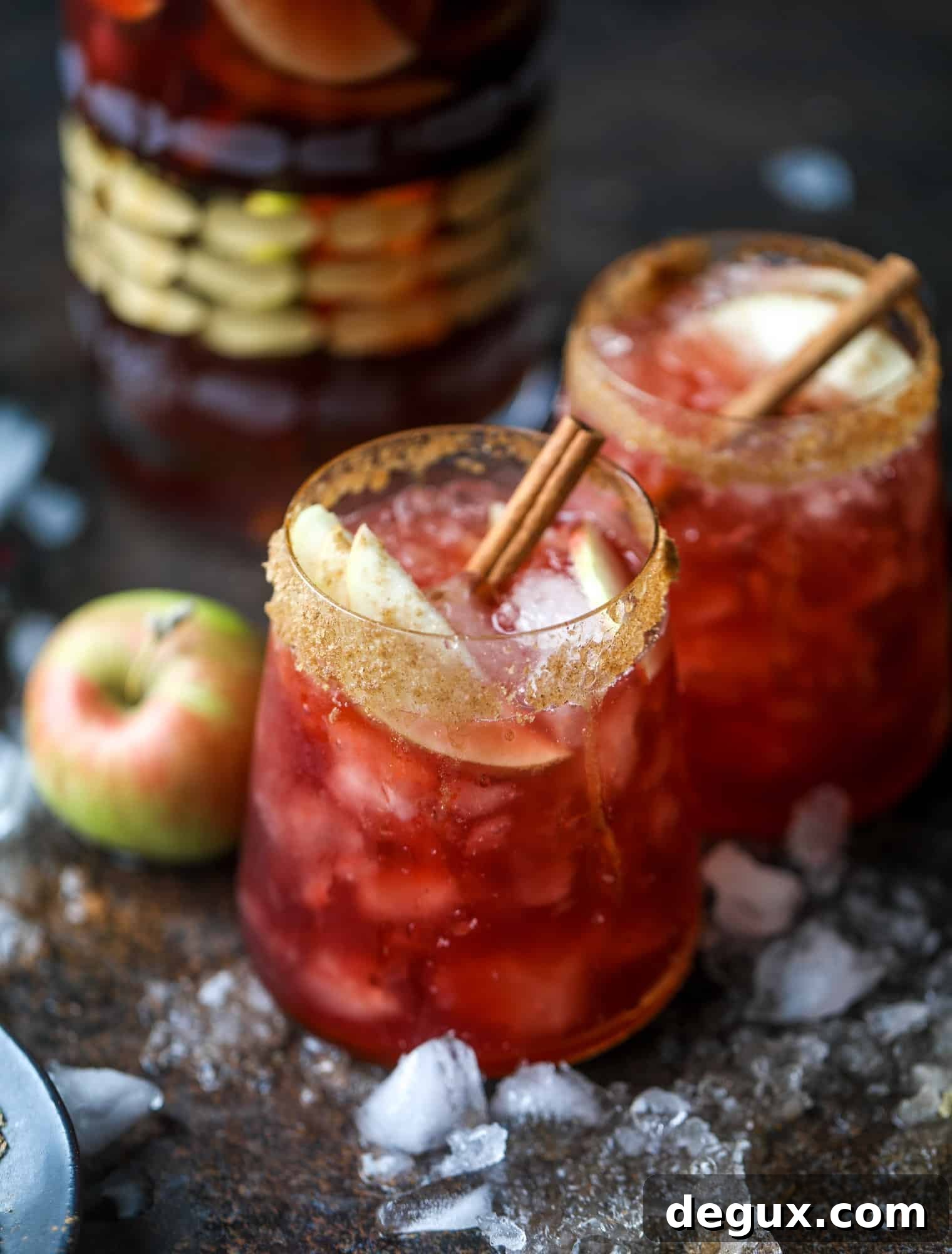 Served glass of red apple cider sangria with apple and cinnamon garnish.