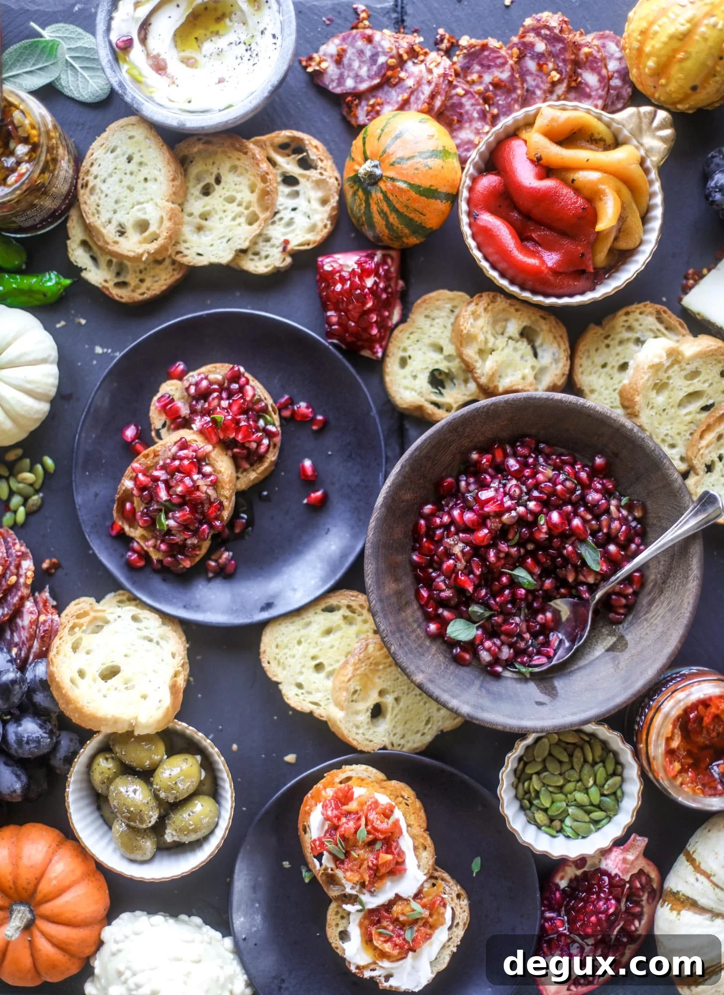 Autumn harvest bruschetta board with pomegranate relish, toasted bread, cheeses and olives