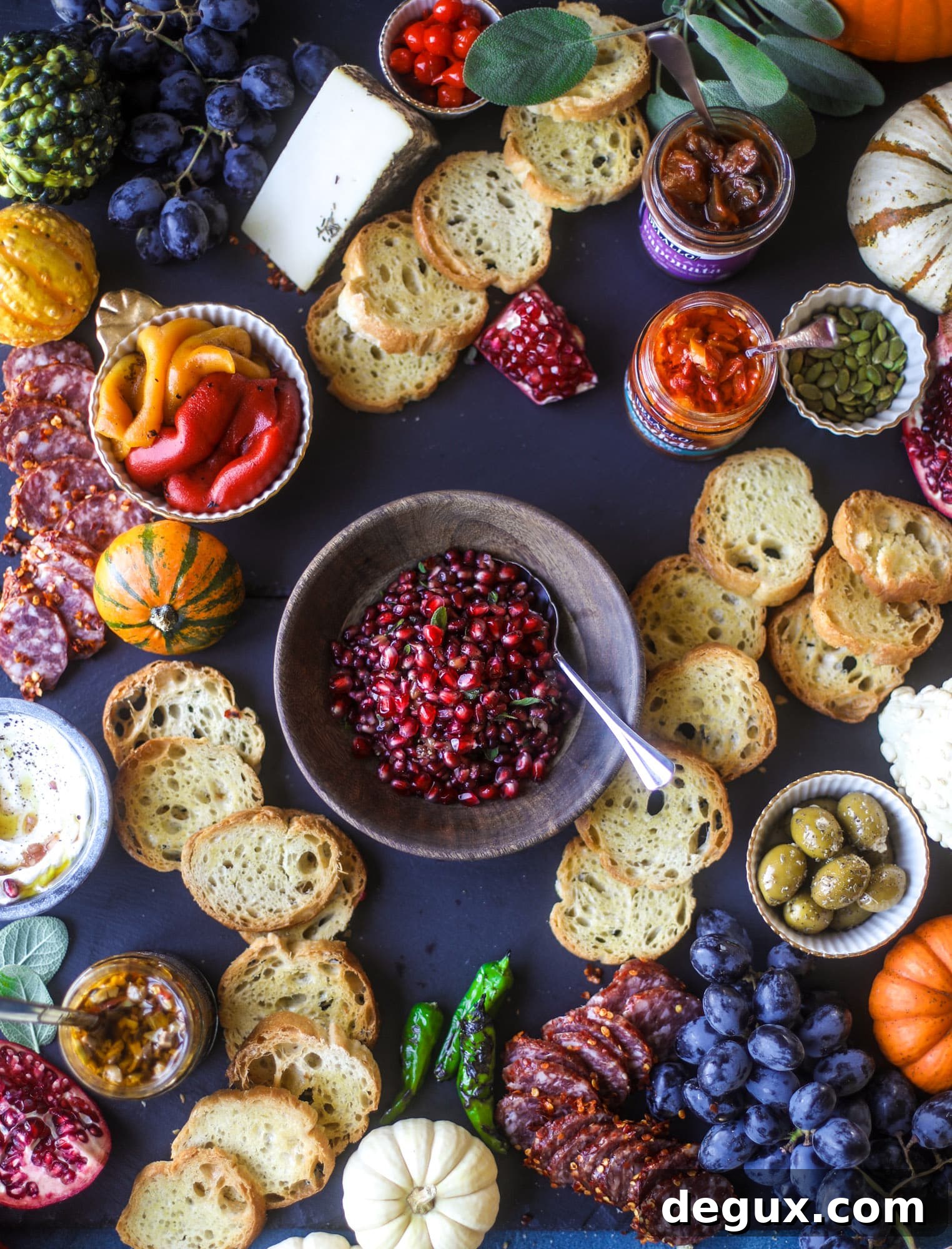 Board with ricotta, roasted peppers, salami and pomegranate relish