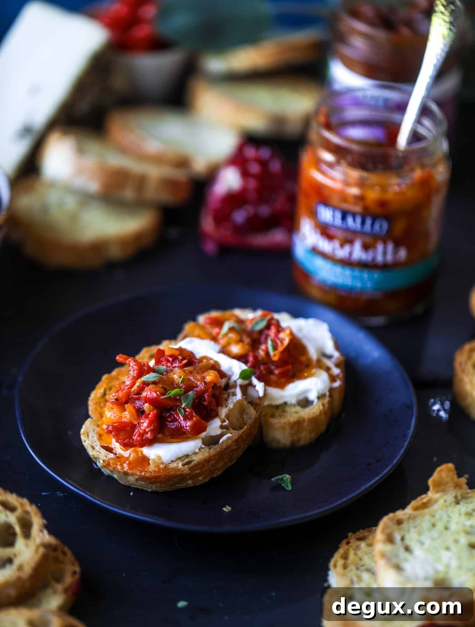 Close-up of bruschetta board featuring pomegranate relish and roasted peppers.