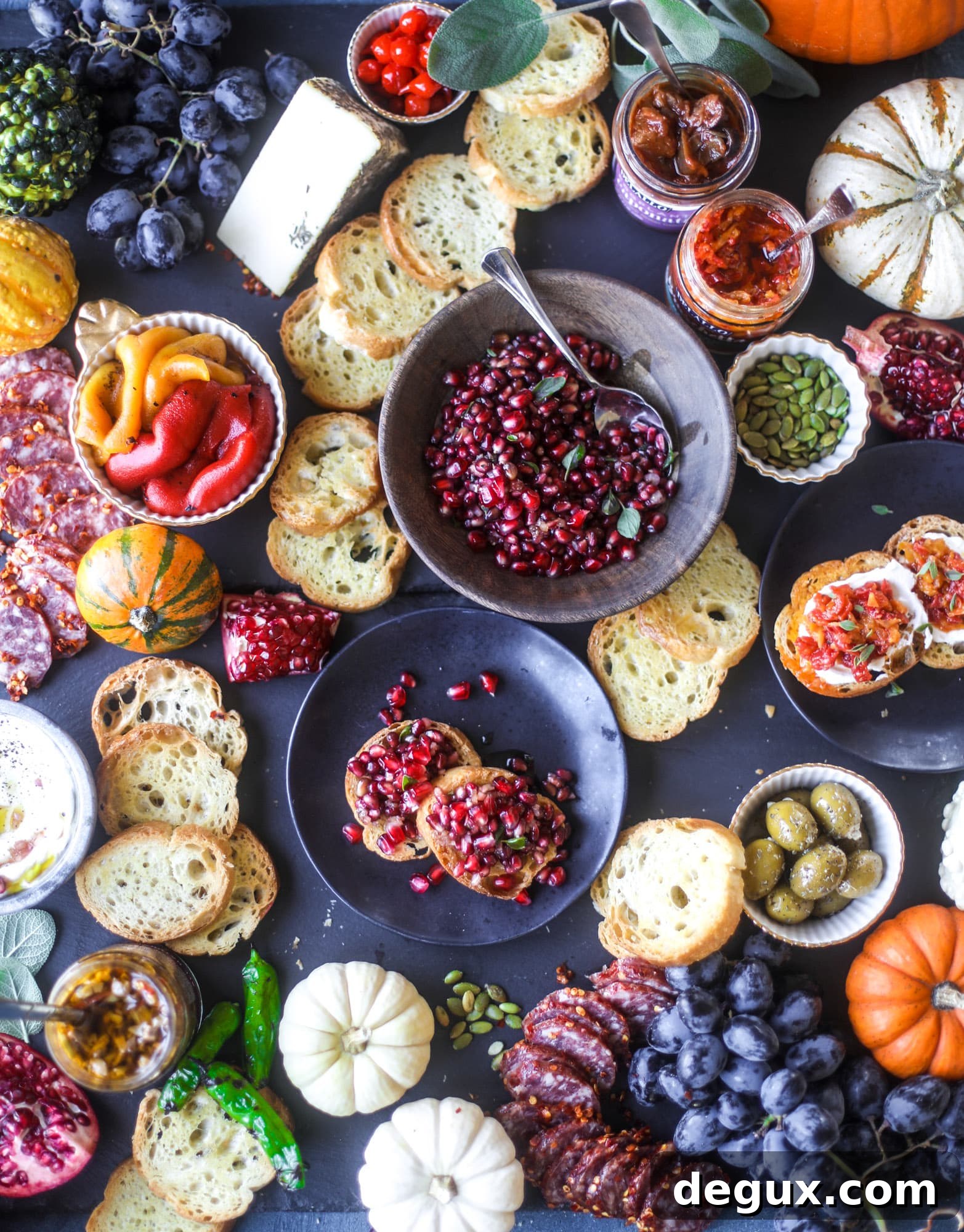 Autumn harvest bruschetta board with pomegranate relish, toasted bread, cheeses and olives