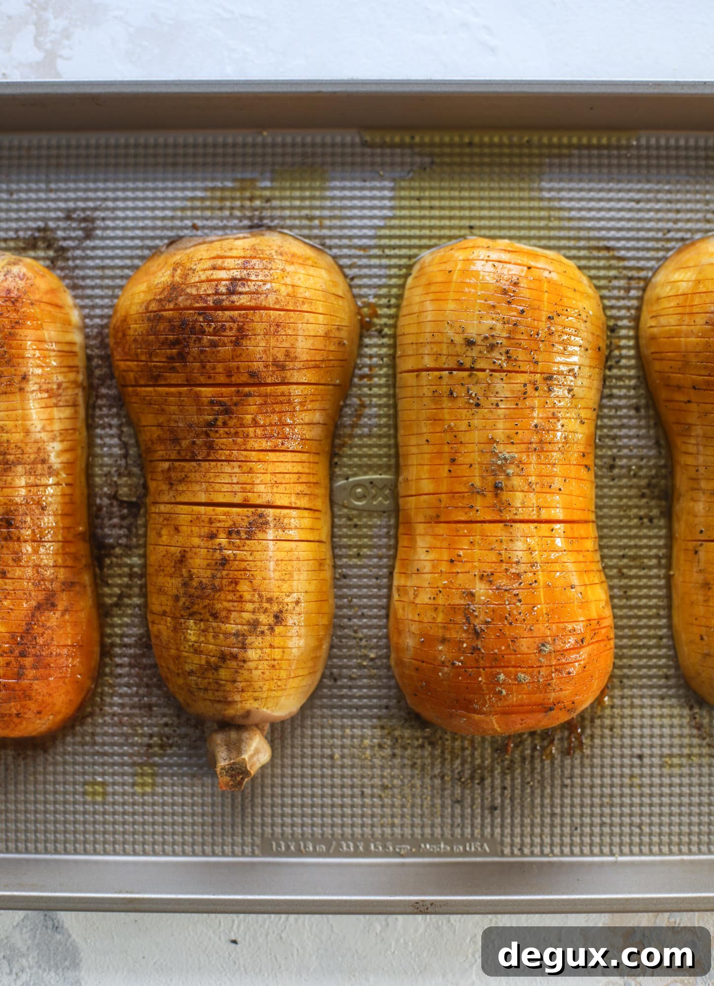 Two flavors of hasselback squash on the same sheet pan: maple pecan and brown butter sage.