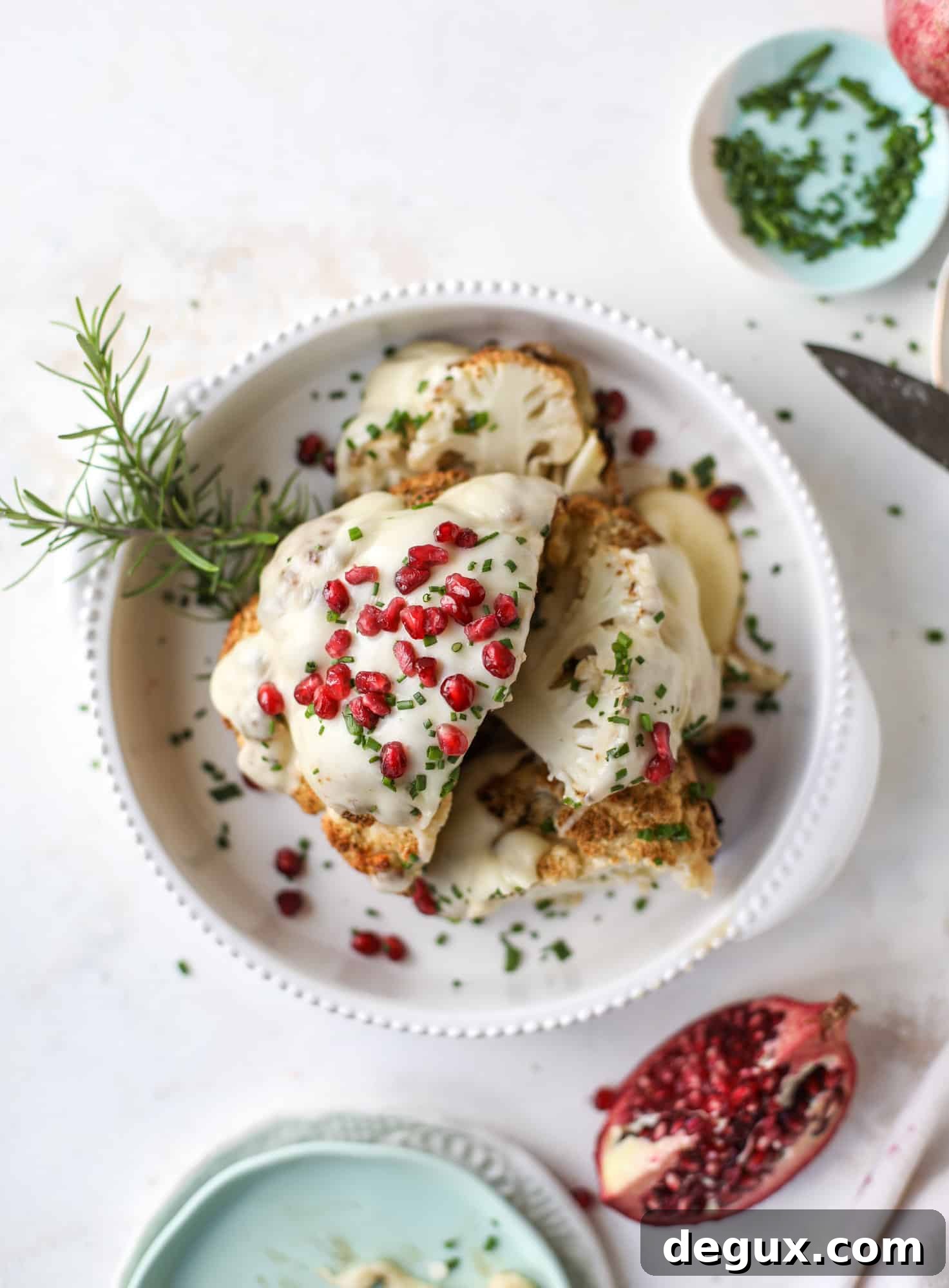 This whole roasted cauliflower fondue is roasted to toasty perfection and then covered in a fondue cheese sauce! Sprinkled with a festive garnish, it's the perfect appetizer or side dish for your dinner party, weeknight meal or movie night! I howsweeteats.com #wholeroasted #cauliflower