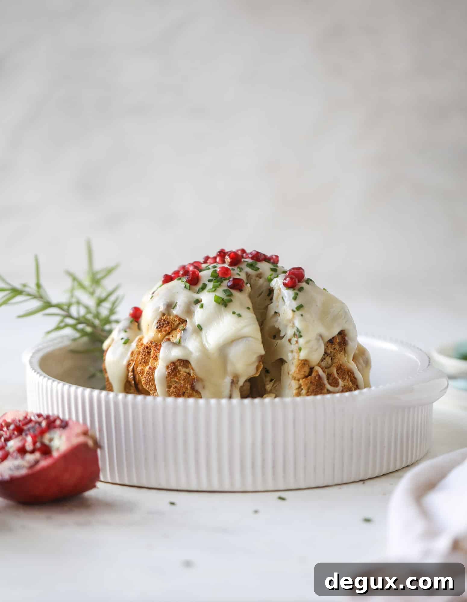 This whole roasted cauliflower fondue is roasted to toasty perfection and then covered in a fondue cheese sauce! Sprinkled with a festive garnish, it's the perfect appetizer or side dish for your dinner party, weeknight meal or movie night! I howsweeteats.com #wholeroasted #cauliflower