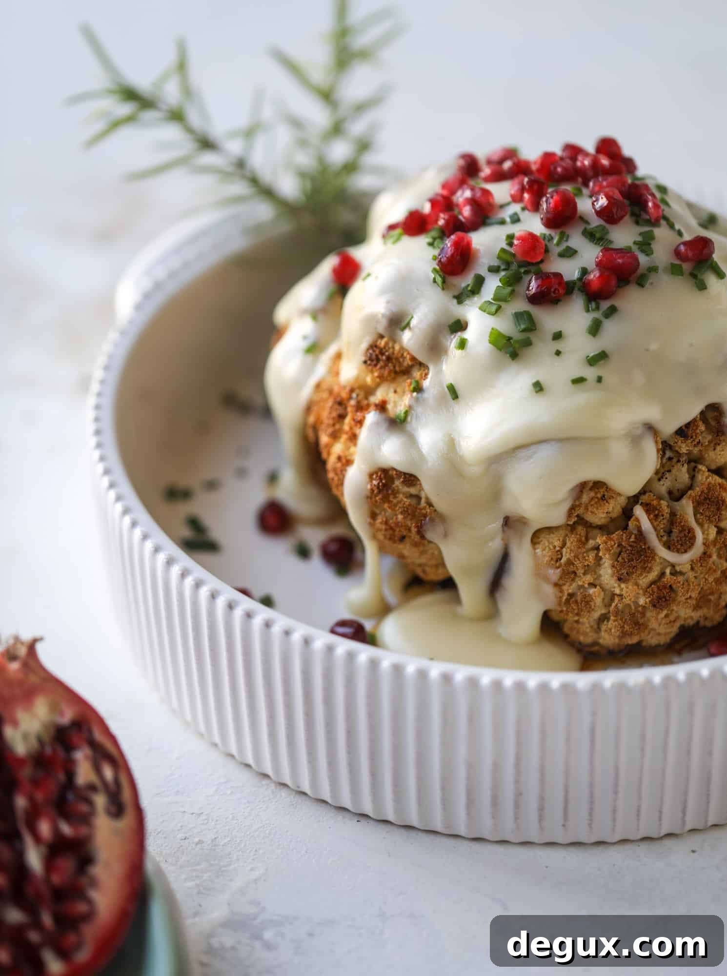 This whole roasted cauliflower fondue is roasted to toasty perfection and then covered in a fondue cheese sauce! Sprinkled with a festive garnish, it's the perfect appetizer or side dish for your dinner party, weeknight meal or movie night! I howsweeteats.com #wholeroasted #cauliflower
