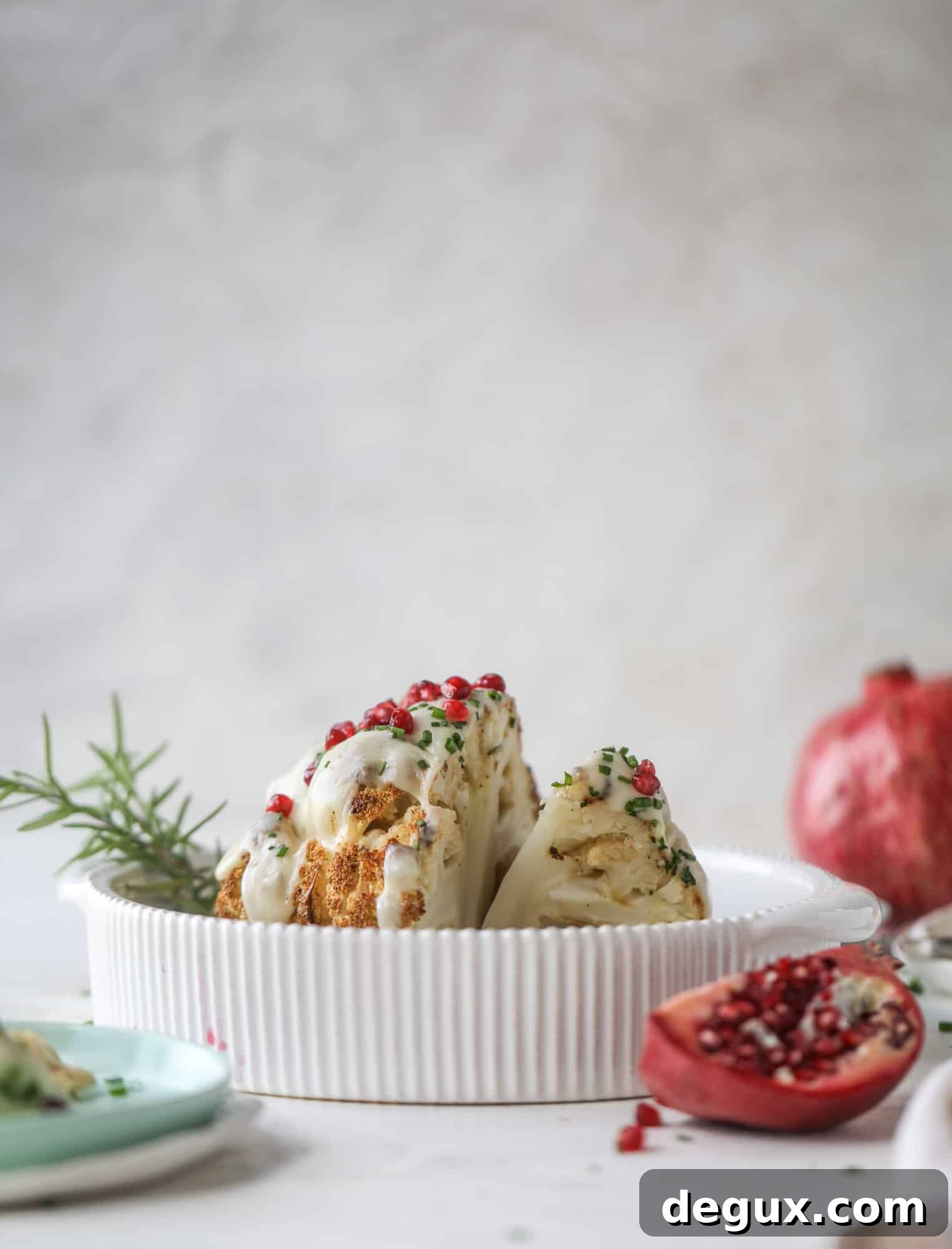 This whole roasted cauliflower fondue is roasted to toasty perfection and then covered in a fondue cheese sauce! Sprinkled with a festive garnish, it's the perfect appetizer or side dish for your dinner party, weeknight meal or movie night! I howsweeteats.com #wholeroasted #cauliflower