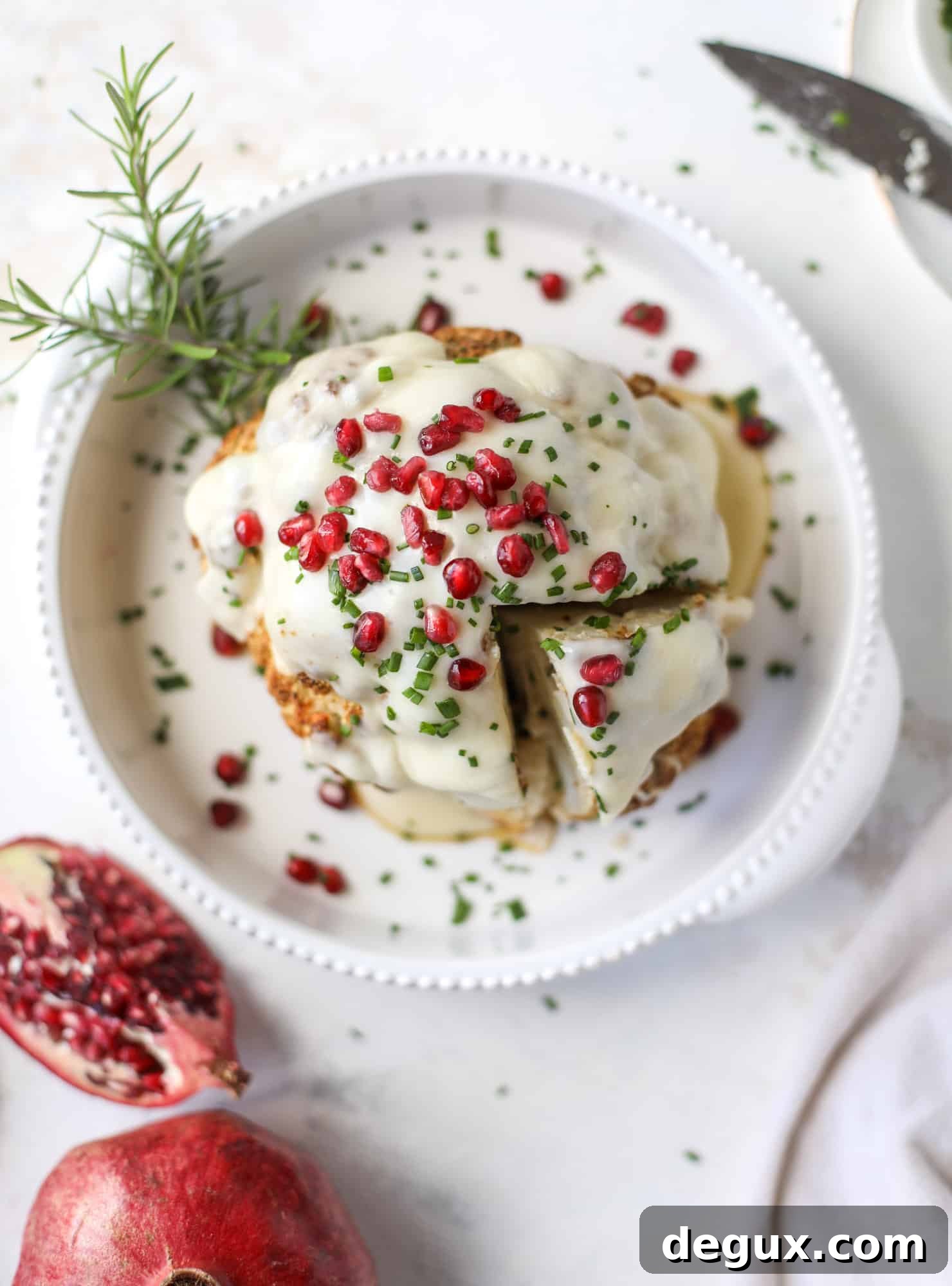 This whole roasted cauliflower fondue is roasted to toasty perfection and then covered in a fondue cheese sauce! Sprinkled with a festive garnish, it's the perfect appetizer or side dish for your dinner party, weeknight meal or movie night! I howsweeteats.com #wholeroasted #cauliflower