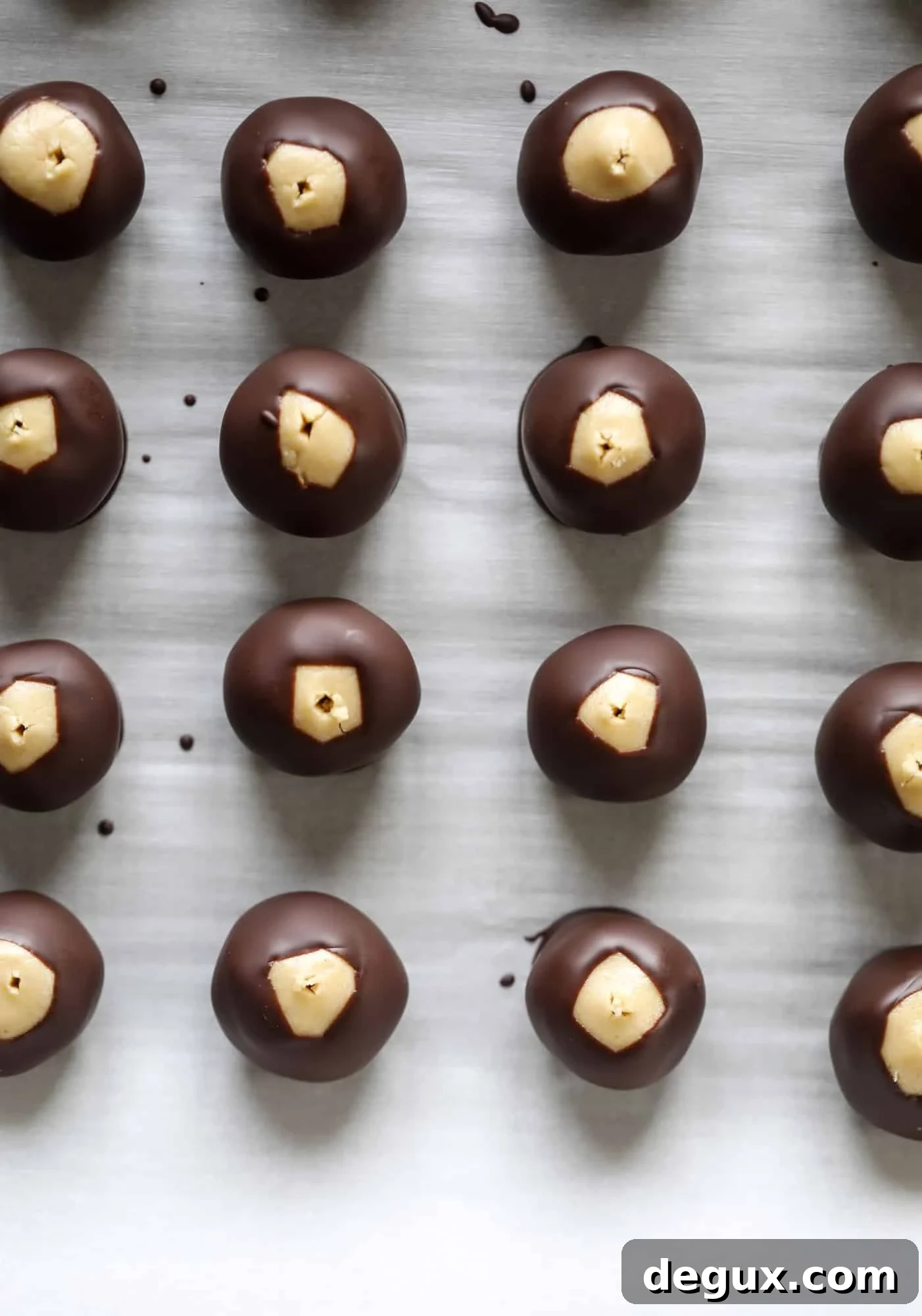 These cashew butter buckeyes are a fun and modern twist on the traditional buckeye recipe! Creamy cashew butter makes a delicious, rich dough and then it's coated in chocolate and sprinkled with sea salt. Delicious! I howsweeteats.com #cashewbutter #buckeyes