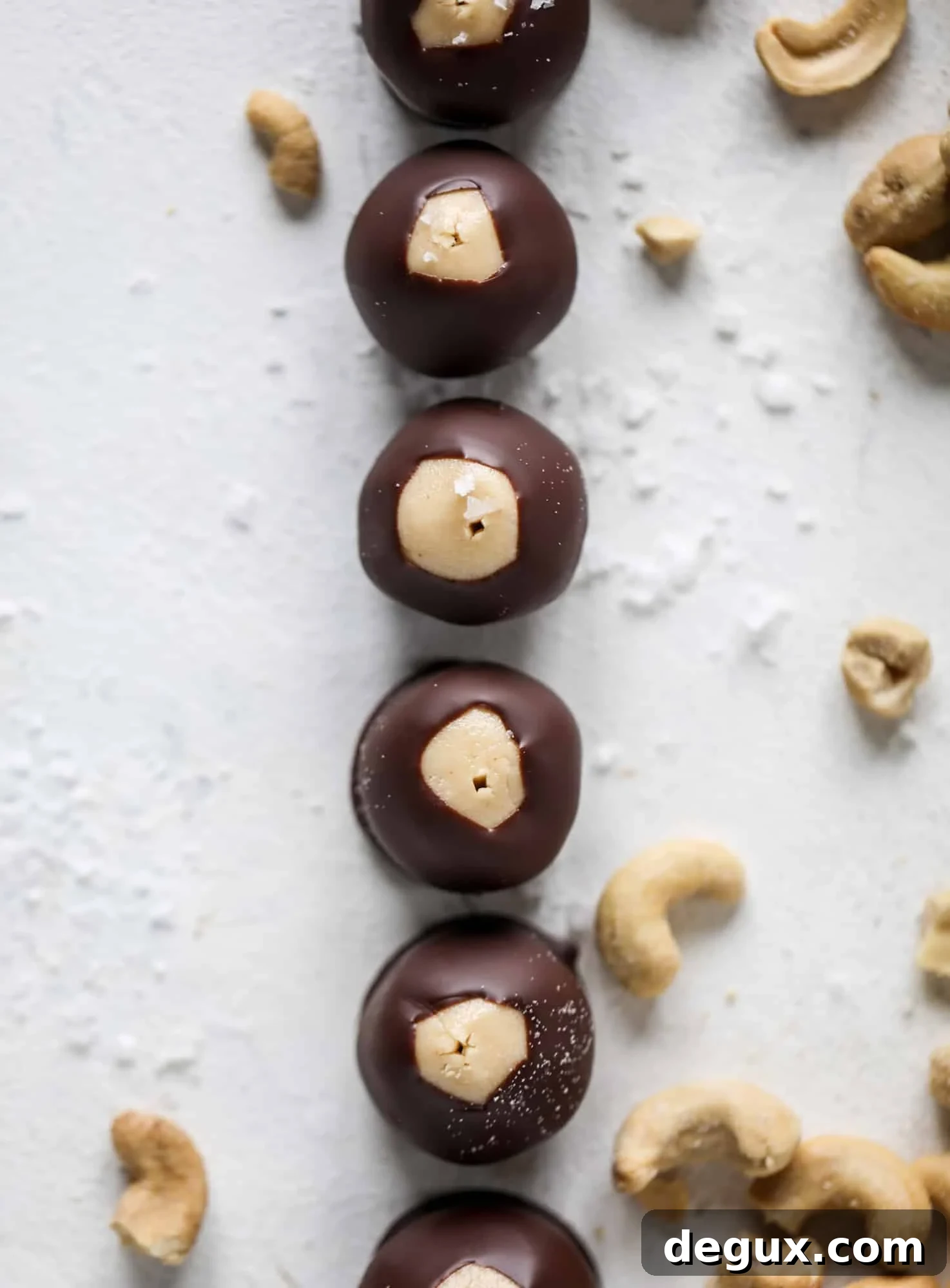 These cashew butter buckeyes are a fun and modern twist on the traditional buckeye recipe! Creamy cashew butter makes a delicious, rich dough and then it's coated in chocolate and sprinkled with sea salt. Delicious! I howsweeteats.com #cashewbutter #buckeyes