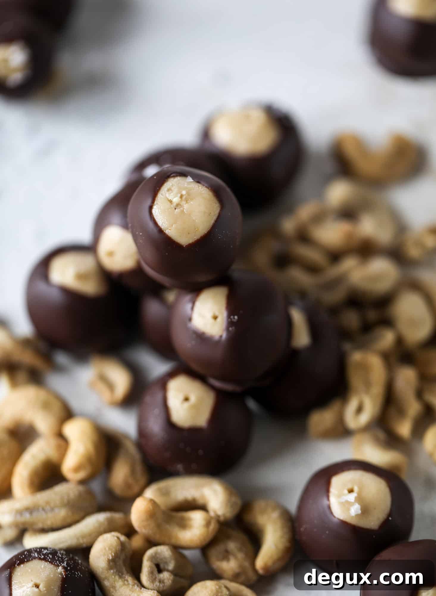 These cashew butter buckeyes are a fun and modern twist on the traditional buckeye recipe! Creamy cashew butter makes a delicious, rich dough and then it's coated in chocolate and sprinkled with sea salt. Delicious! I howsweeteats.com #cashewbutter #buckeyes