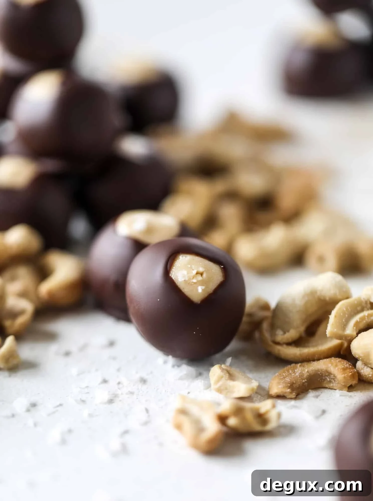 These cashew butter buckeyes are a fun and modern twist on the traditional buckeye recipe! Creamy cashew butter makes a delicious, rich dough and then it's coated in chocolate and sprinkled with sea salt. Delicious! I howsweeteats.com #cashewbutter #buckeyes