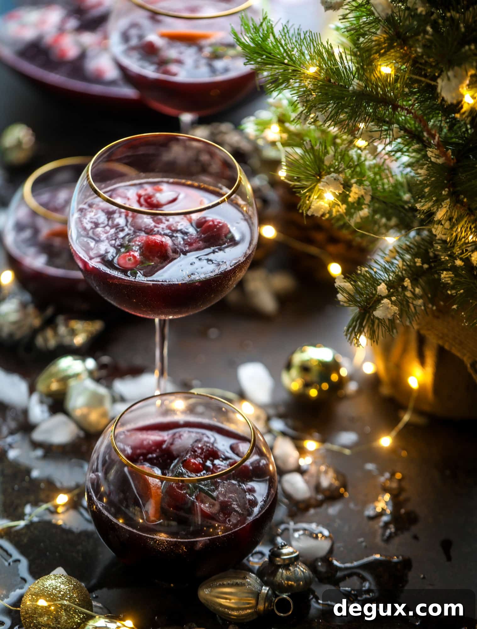This tree trimming punch is the most perfect Christmas punch to drink while decorating the tree! Rich red wine is the base and there's a bit of orange, some spice, cinnamon and a gorgeous jeweled holiday ice cubes!