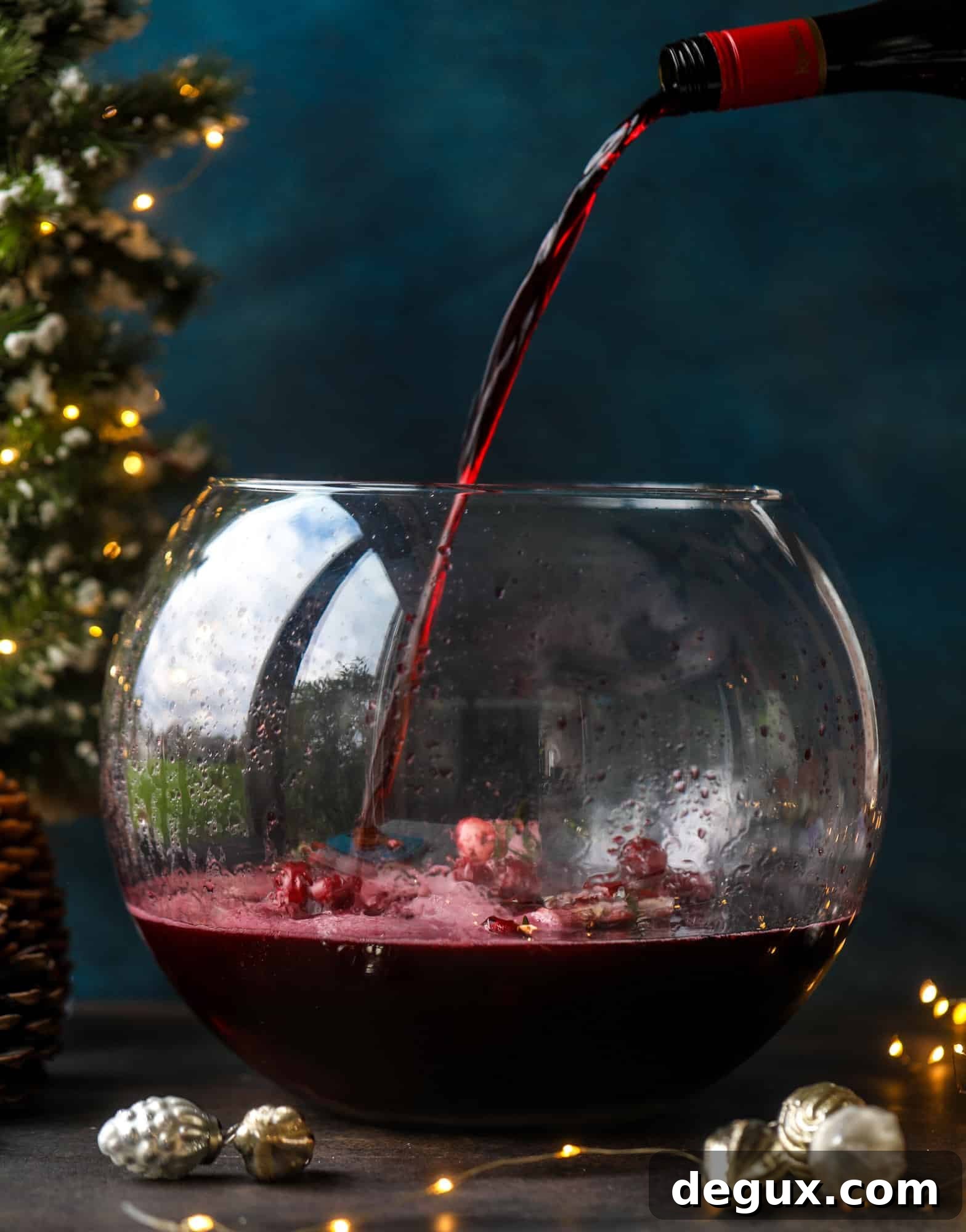This tree trimming punch is the most perfect Christmas punch to drink while decorating the tree! Rich red wine is the base and there's a bit of orange, some spice, cinnamon and a gorgeous jeweled holiday ice cubes!