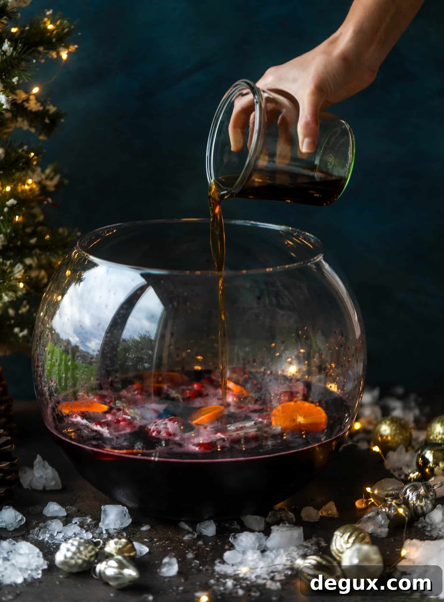 This tree trimming punch is the most perfect Christmas punch to drink while decorating the tree! Rich red wine is the base and there's a bit of orange, some spice, cinnamon and a gorgeous jeweled holiday ice cubes!