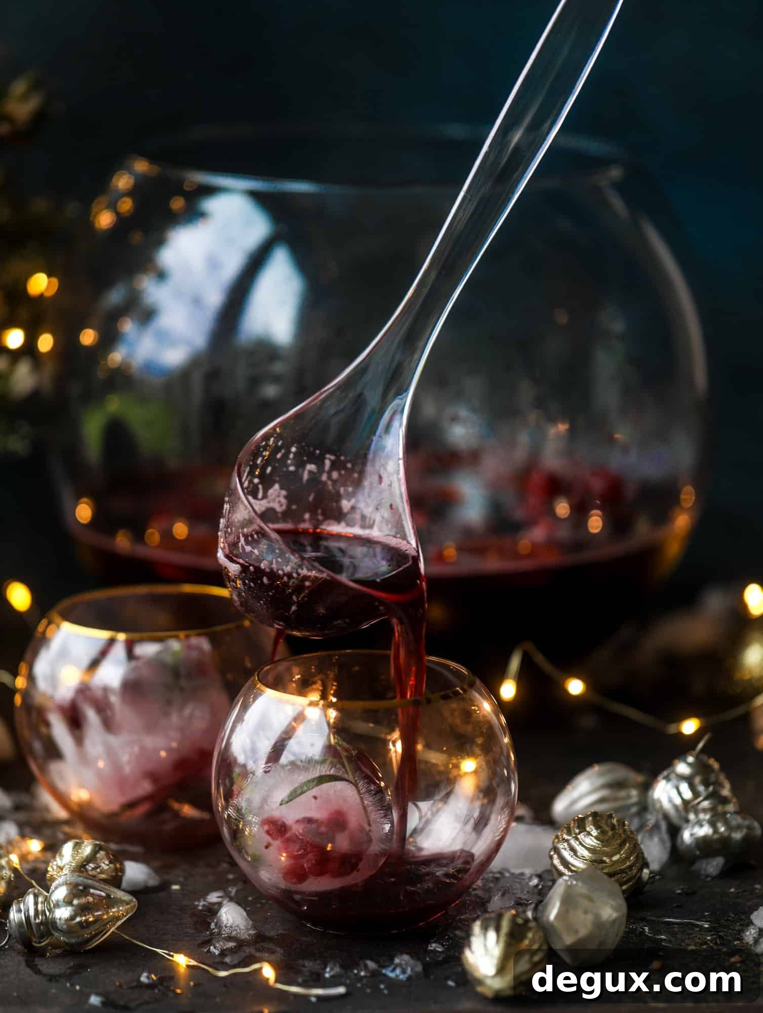 This tree trimming punch is the most perfect Christmas punch to drink while decorating the tree! Rich red wine is the base and there's a bit of orange, some spice, cinnamon and a gorgeous jeweled holiday ice cubes!