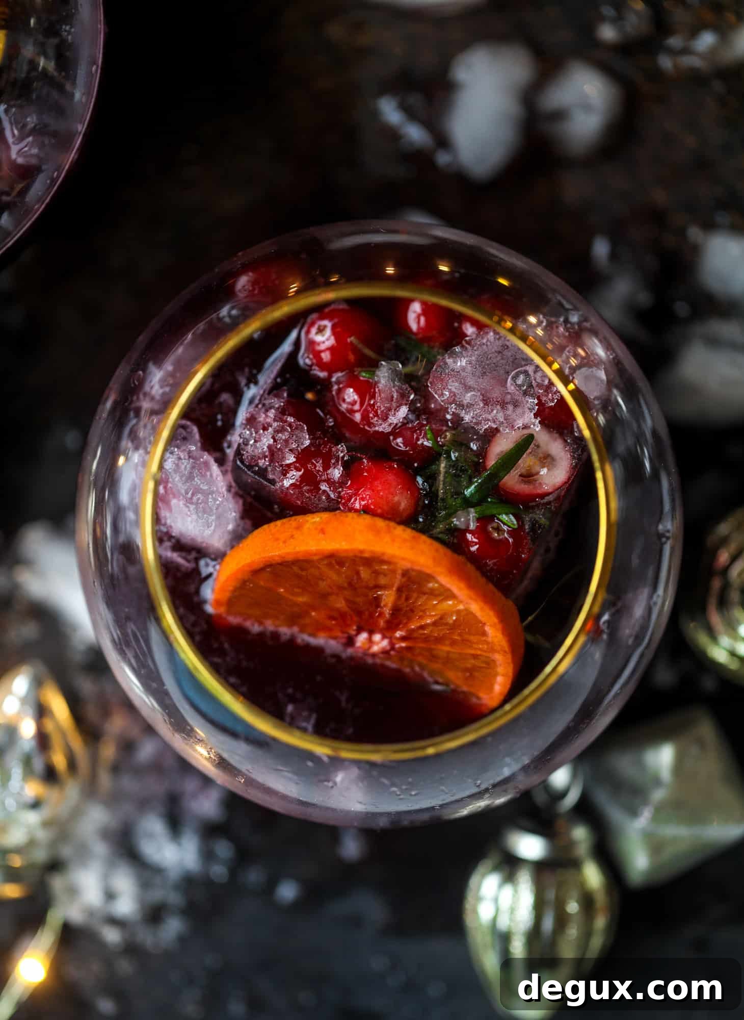 This tree trimming punch is the most perfect Christmas punch to drink while decorating the tree! Rich red wine is the base and there's a bit of orange, some spice, cinnamon and a gorgeous jeweled holiday ice cubes!