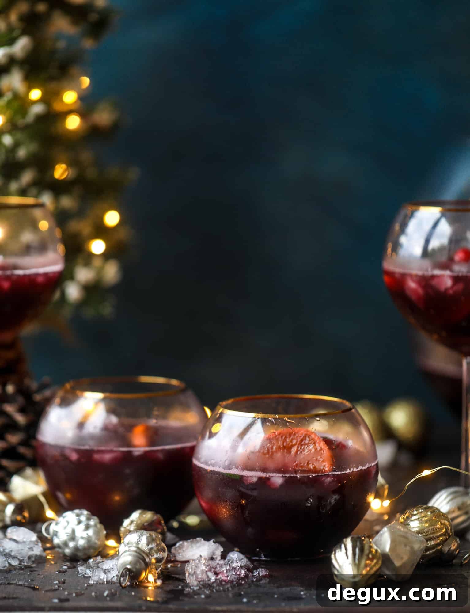 This tree trimming punch is the most perfect Christmas punch to drink while decorating the tree! Rich red wine is the base and there's a bit of orange, some spice, cinnamon and a gorgeous jeweled holiday ice cubes!