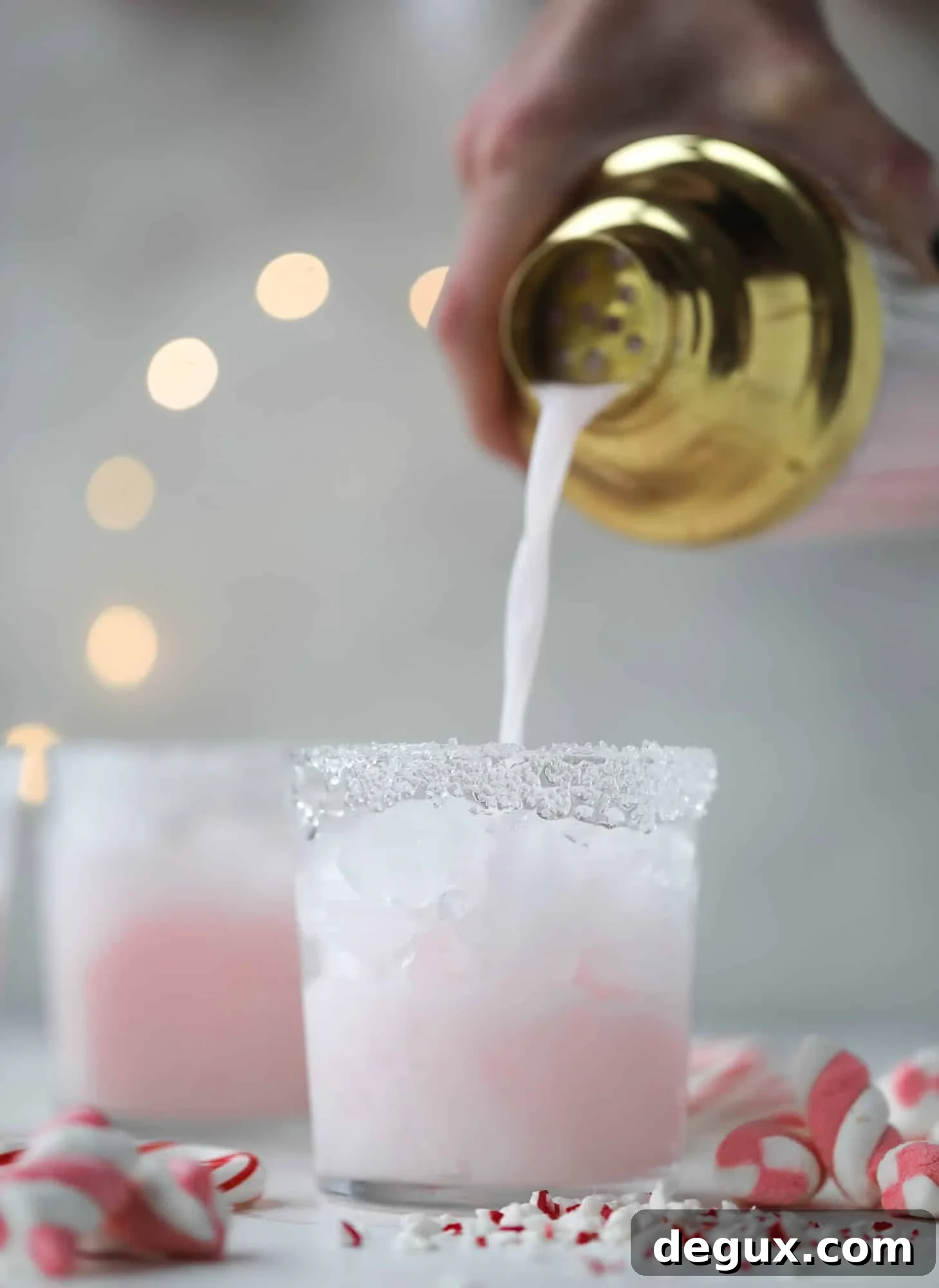 This pink peppermint cocktail is full of holiday cheer! Candy cane vodka, creme de cacao, vanilla and a drop of cream come together to create the perfect iced holiday drink that tastes like a treat! I howsweeteats.com #pinkpeppermint #cocktail