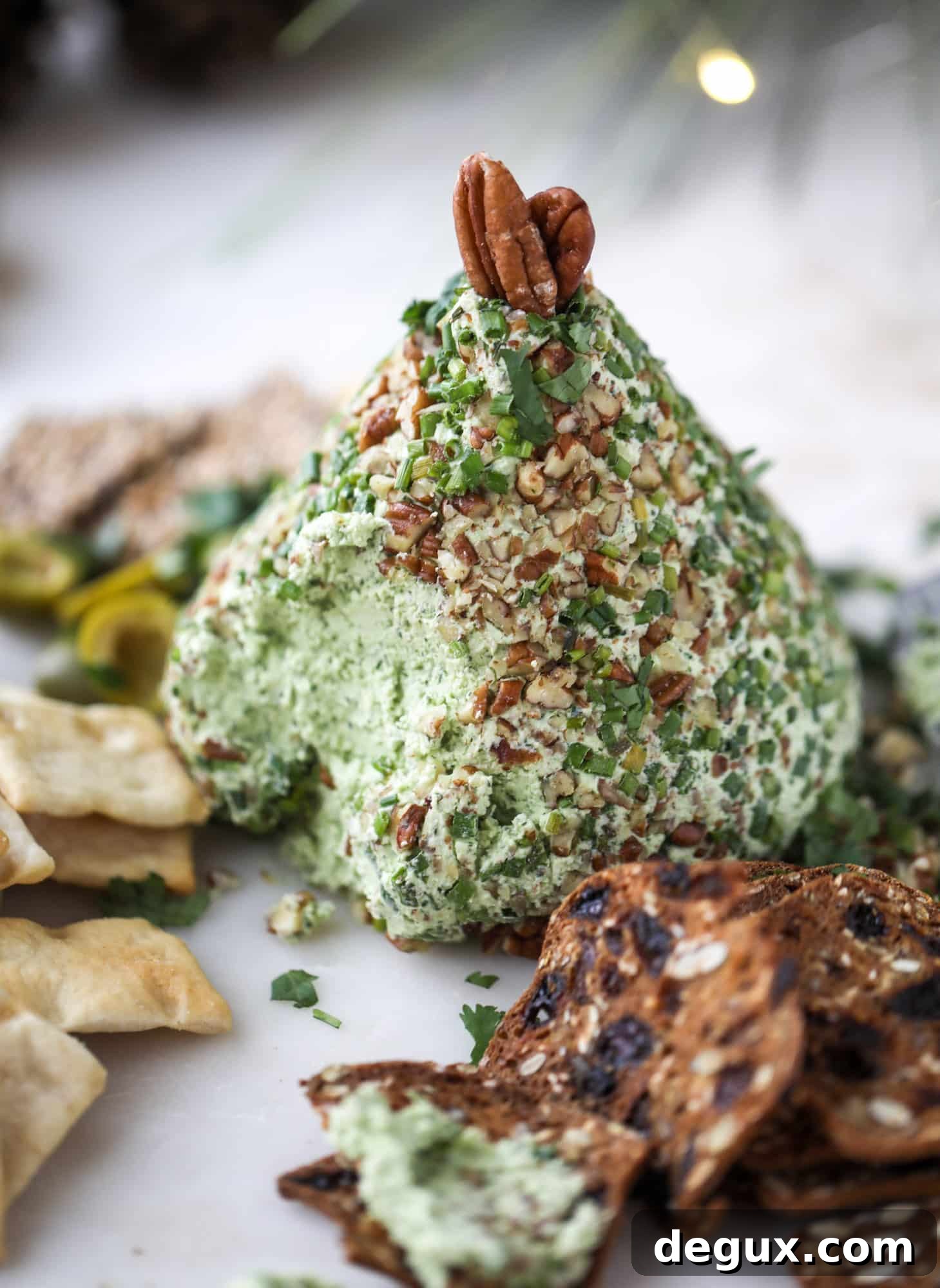 Creamy Green Goddess Cheese Ball Recipe for Parties 8 This green goddess cheese ball is the perfect party snack! You can make it ahead of time and shape it into a cute tree for a festive look. Serve it with crispy crackers and pita chips!