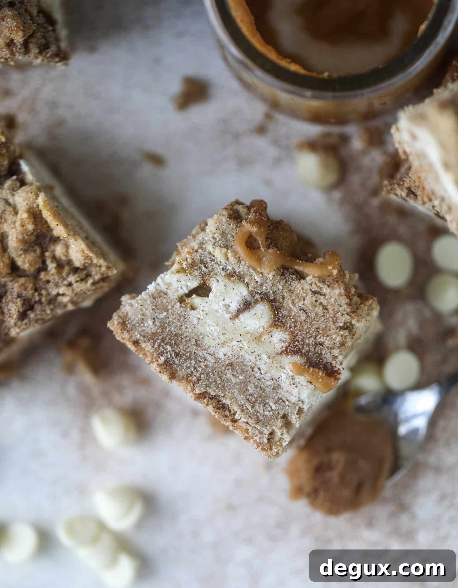 These snickerdoodle caramelitas have a layer of chewy, cinnamon sugared oatmeal bar topped with cream white chocolate and more crumbly, chewy oatmeal bites. They are super delicious and festive! I howsweeteats.com #snickerdoodle #caramelitas